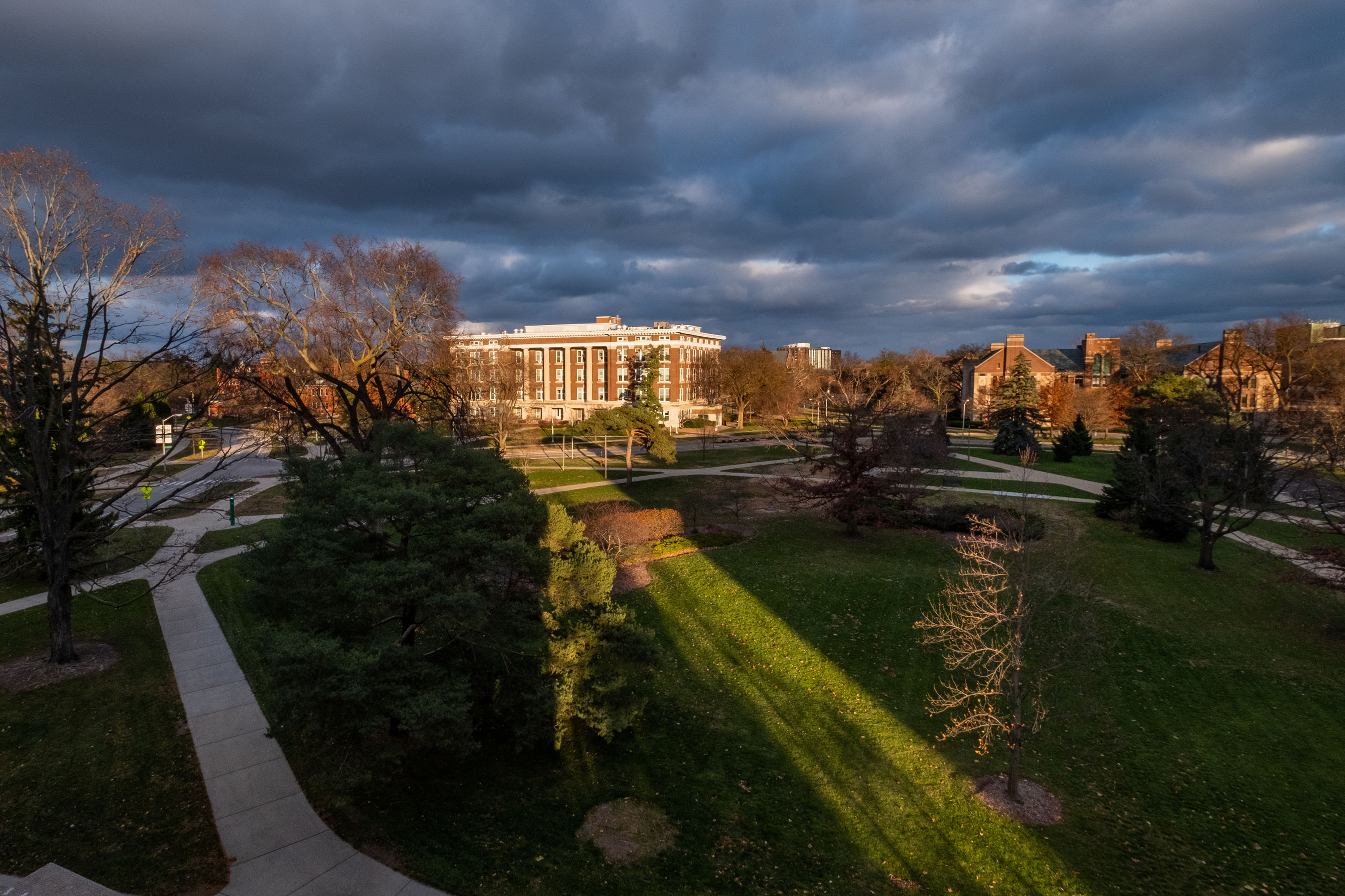 An arial shot looking at Morrill Hall of Agriculture with storm clouds in the sky and one ray of sun.