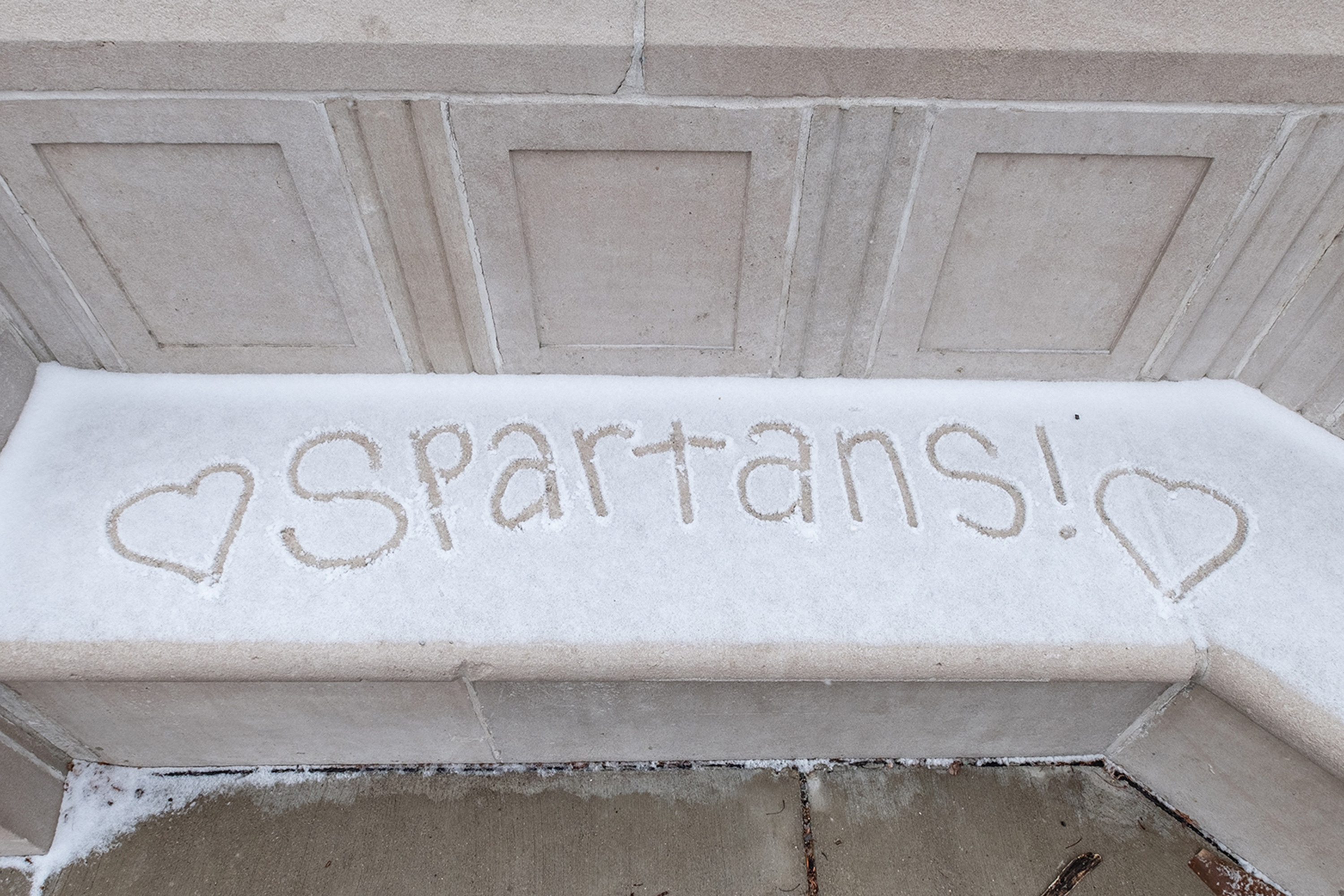 snowy bench with the words written in the snow, 'Spartans' with hearts
