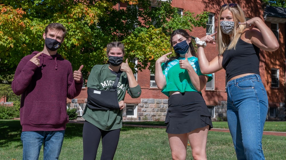 Four students displaying their masks