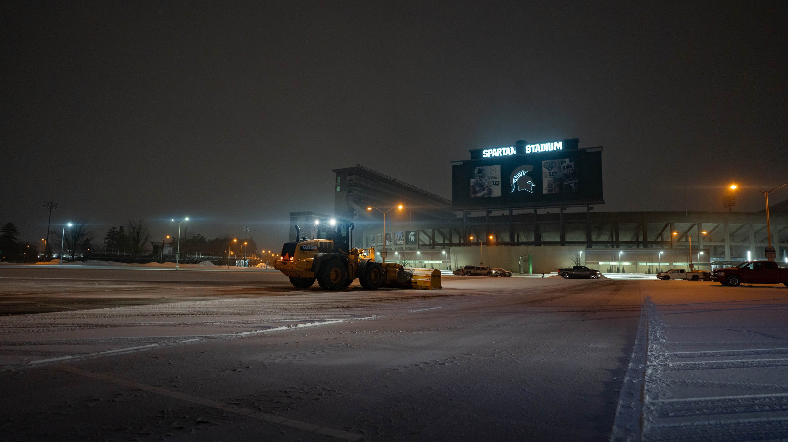 A snow plow clears the snow in front of Spartan Stadium