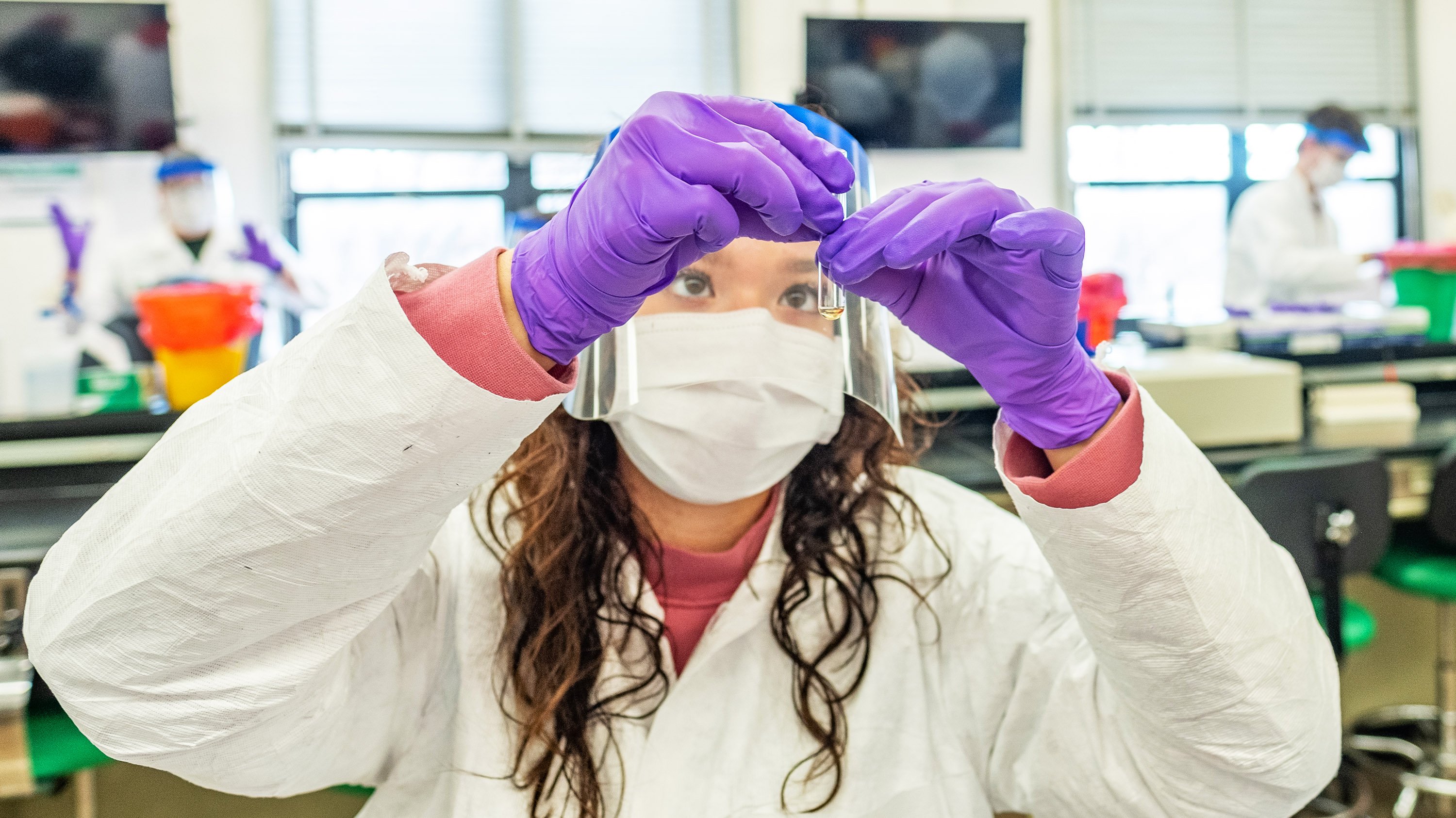 Student holding up a vial in a lab