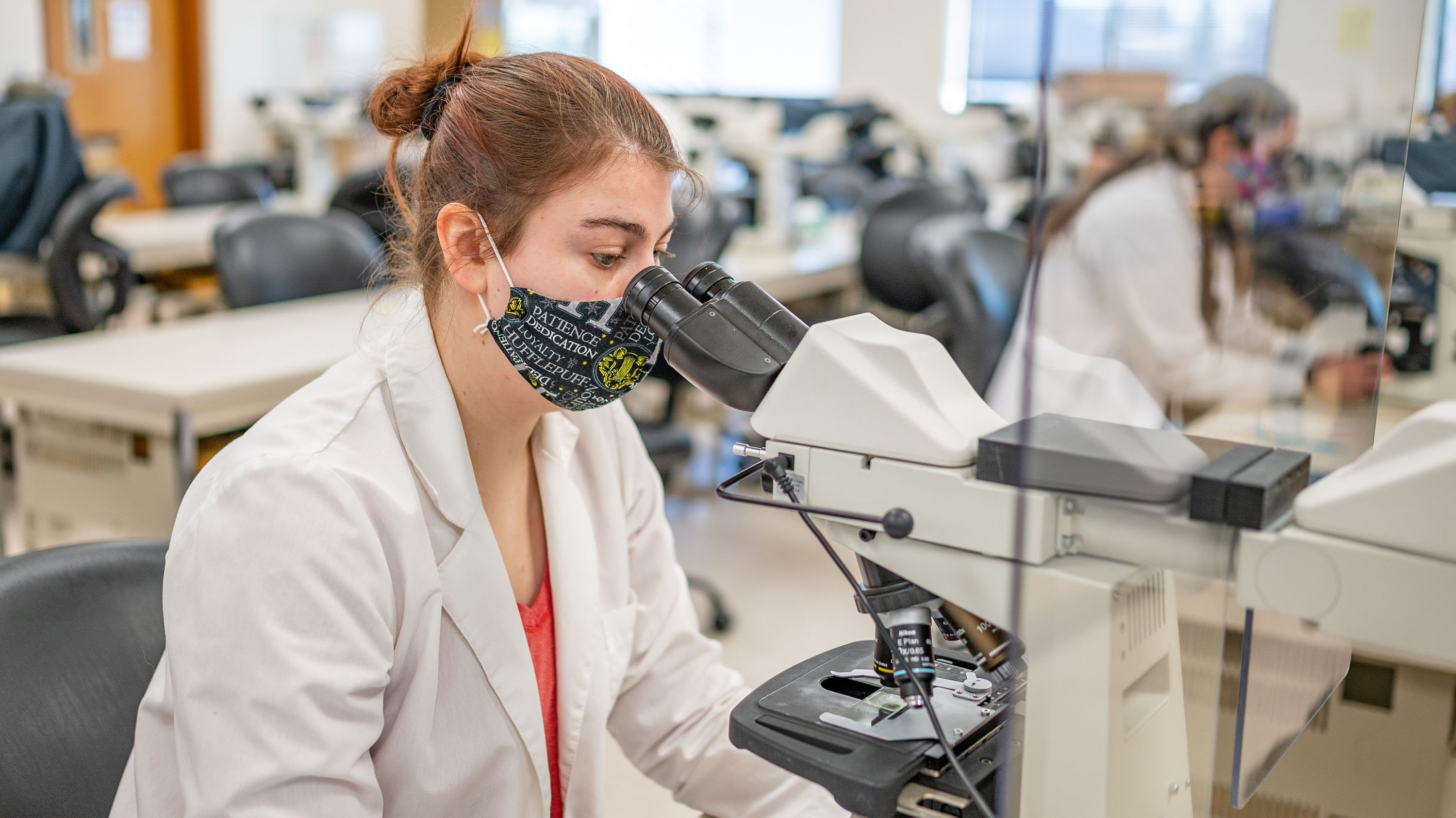 Student looking into a microscope