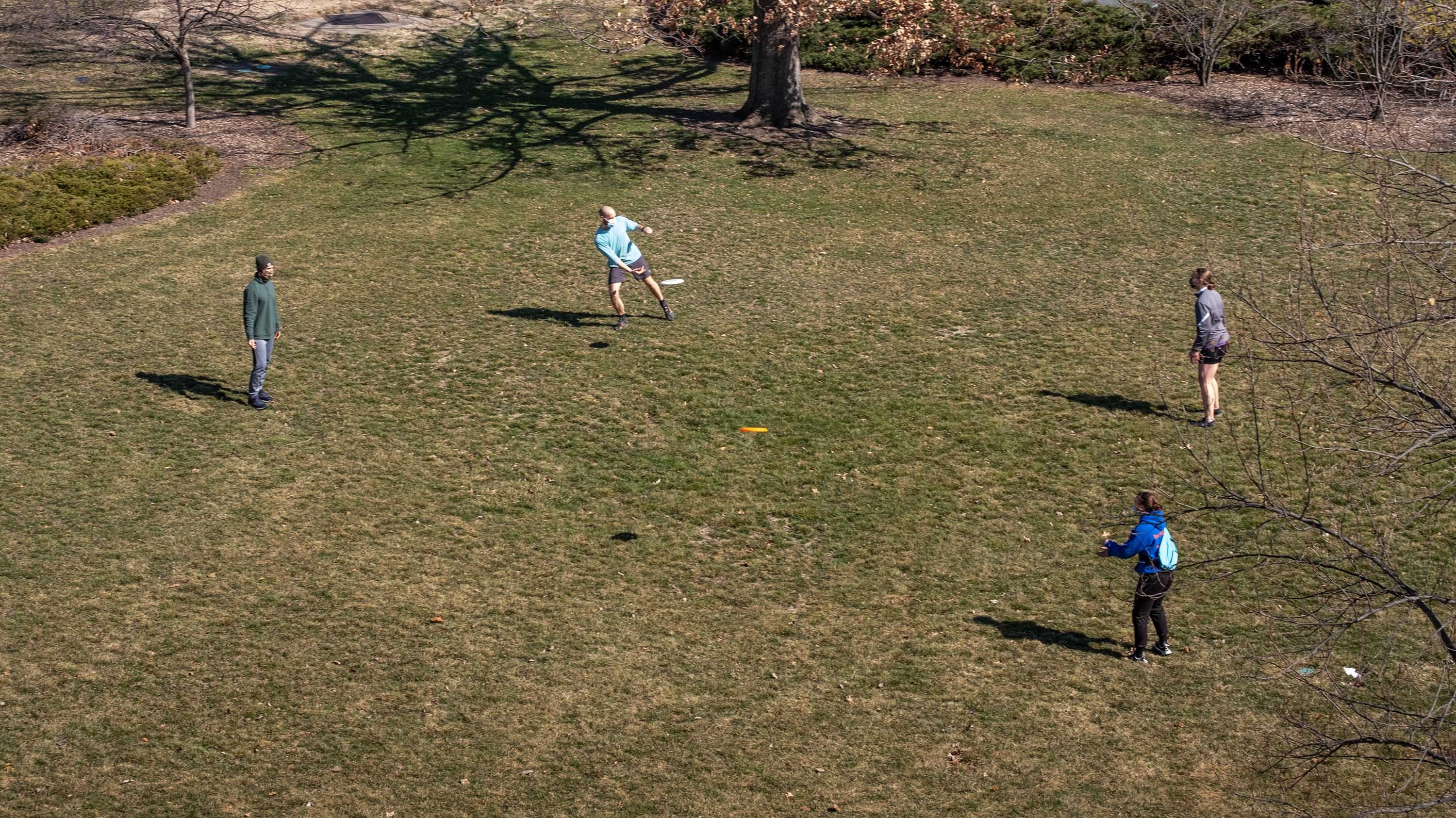 Four students playing frisbee, seen from above