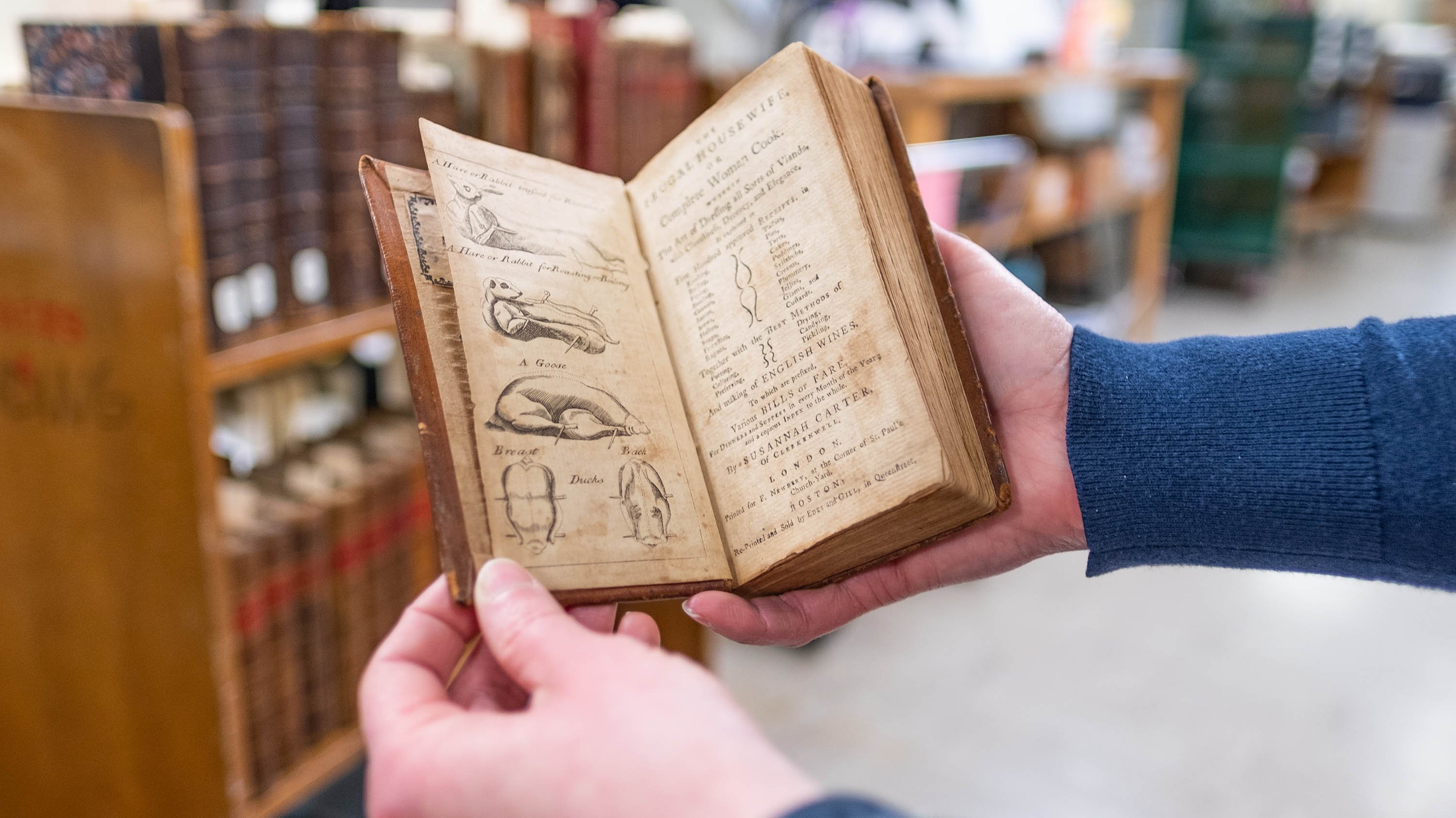 Person holding antique cookbook