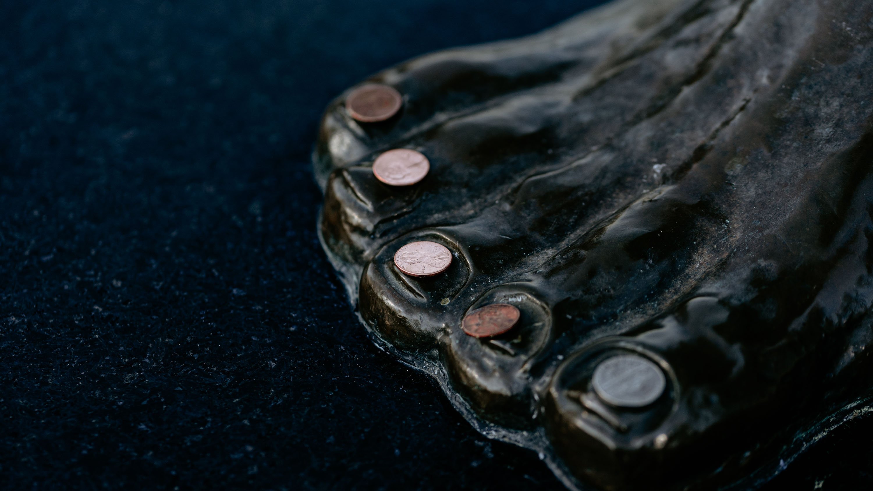 Coins placed on the feet of the Spartan Statue