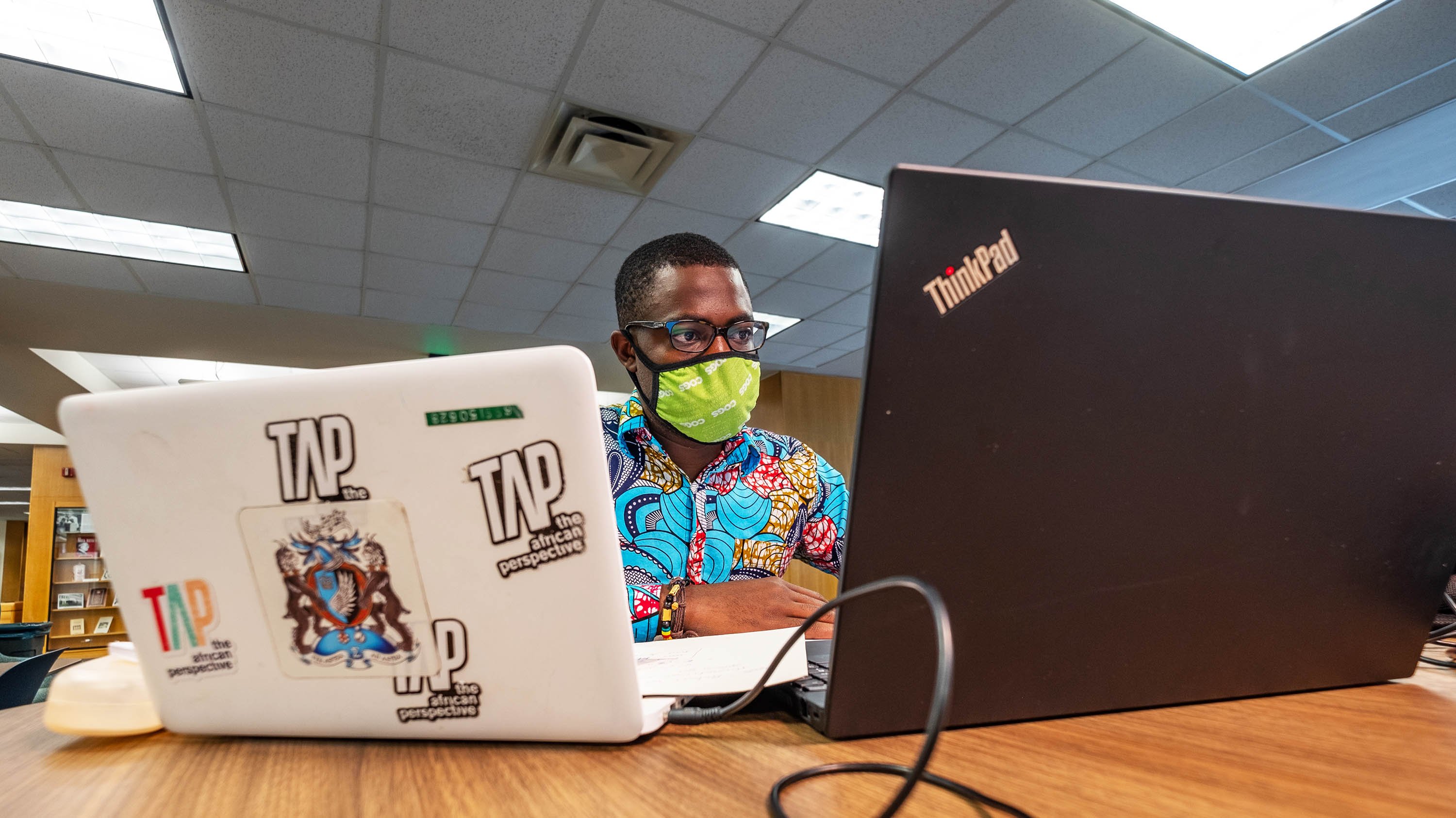 Person working on two laptops in the MSU library,.