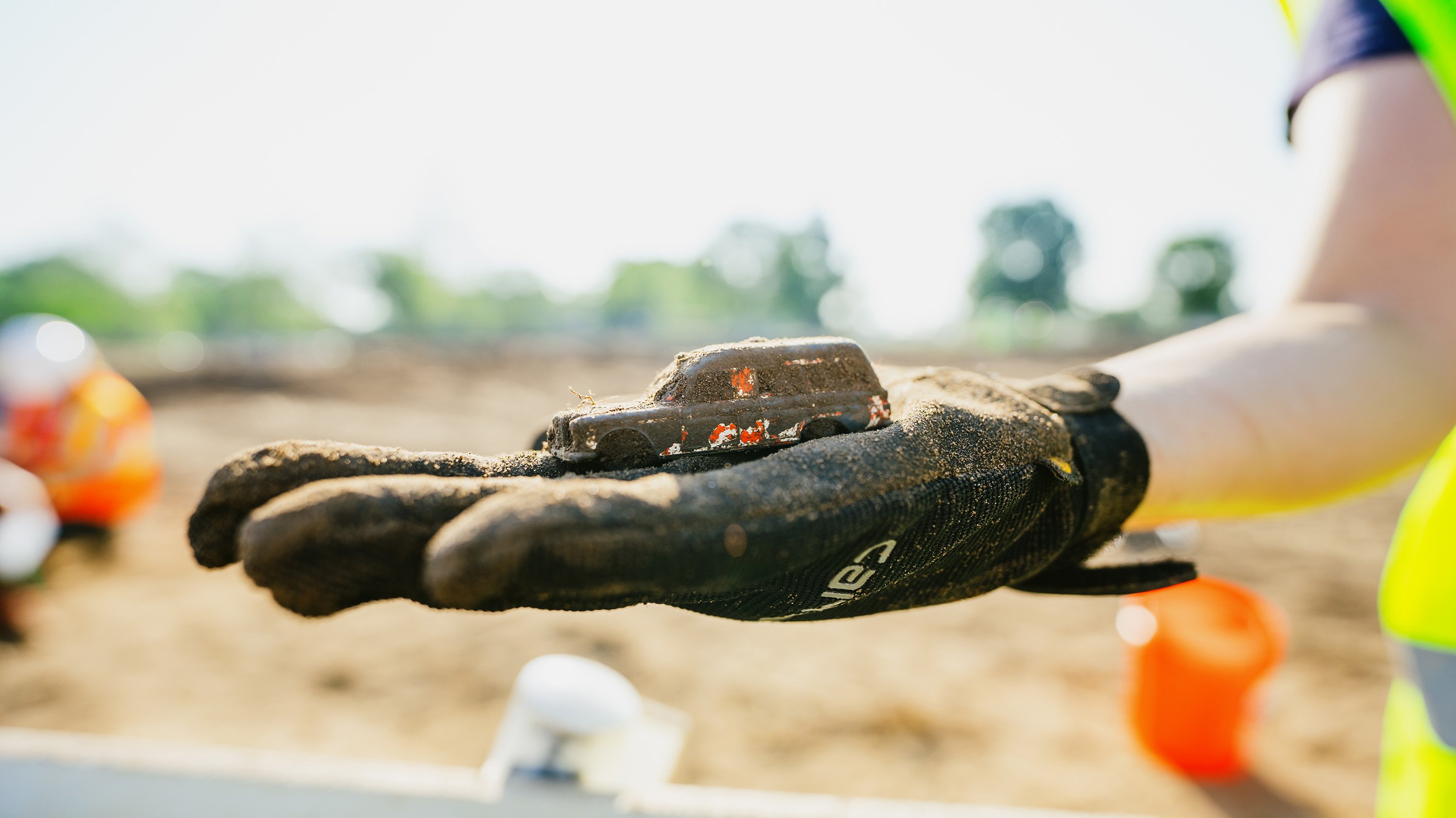 Campus archaeology team member holding a toy car 