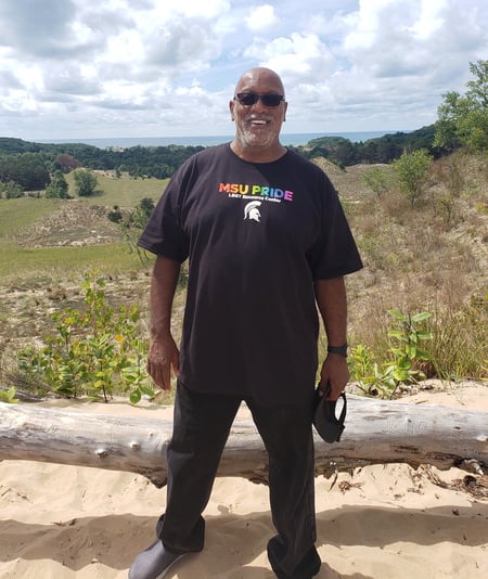 Ronald Moore wearing an MSU Pride t-shirt standing outside.