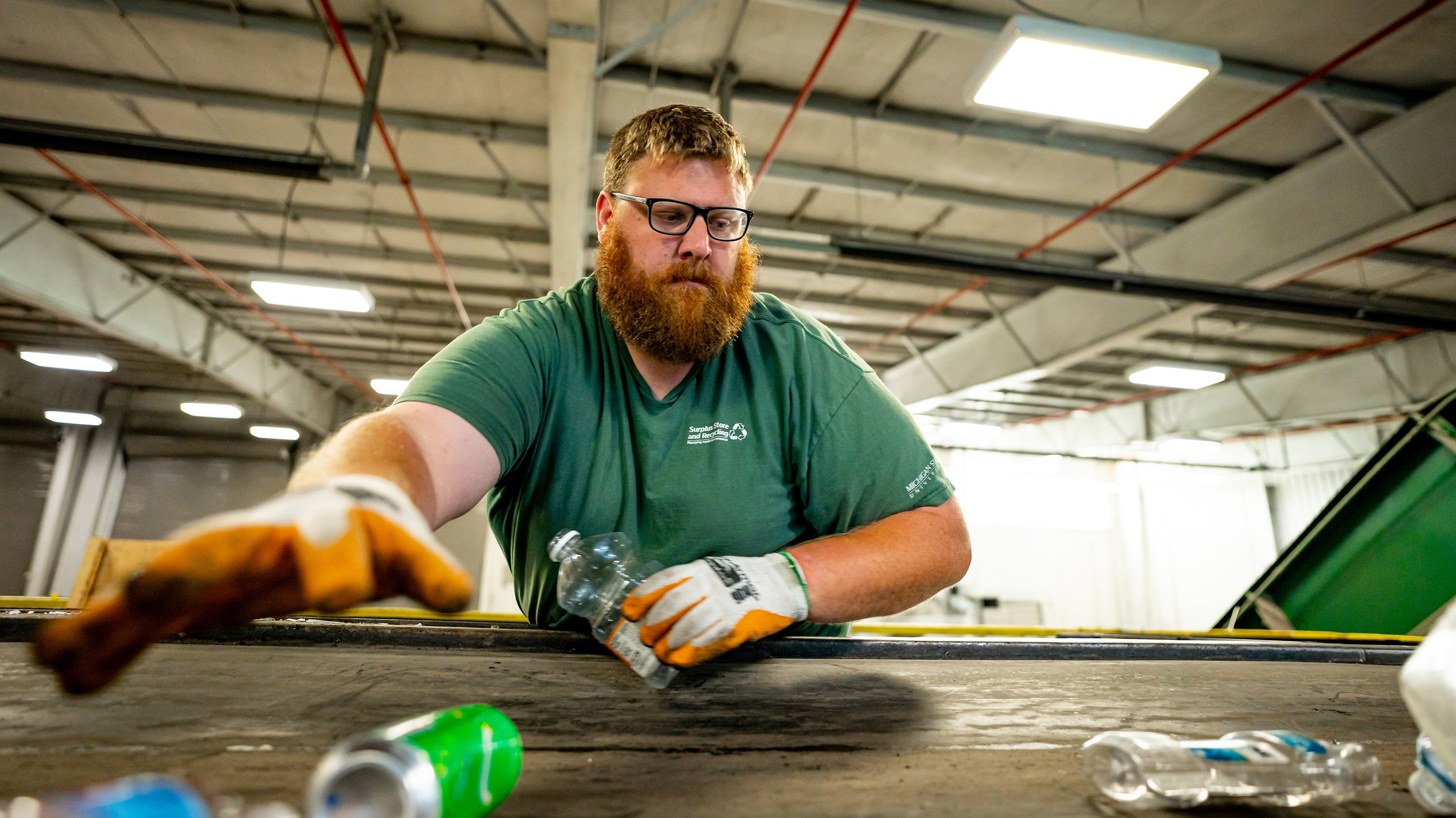 MSU Recycling employee Bryant Schmitt sorting recyclables