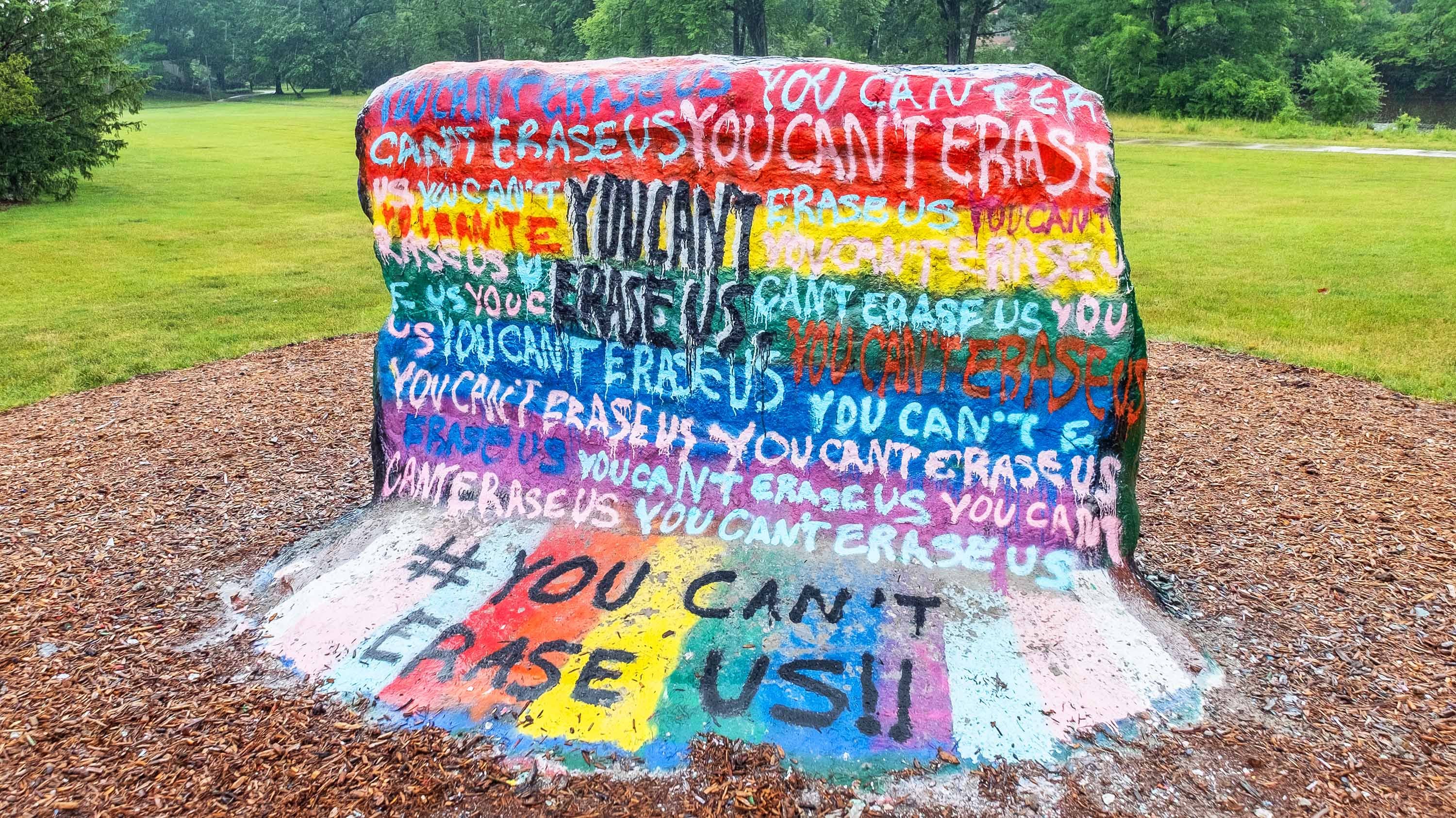 The MSU Rock, painted with a rainbow background and the repeating phrase 'You can't erase us.'