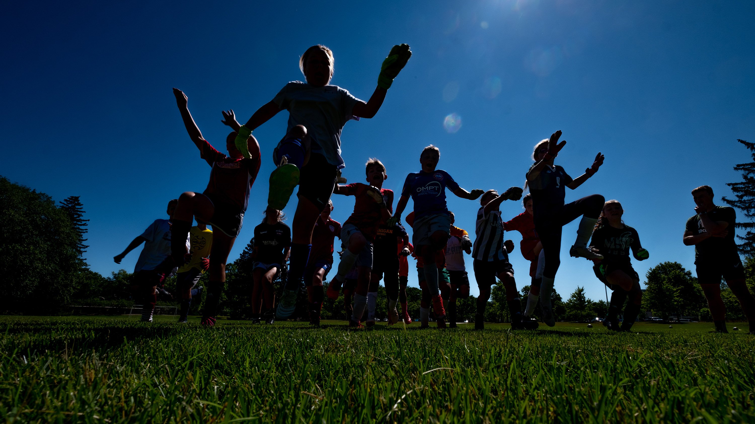 Silhouettes of children playing soccer