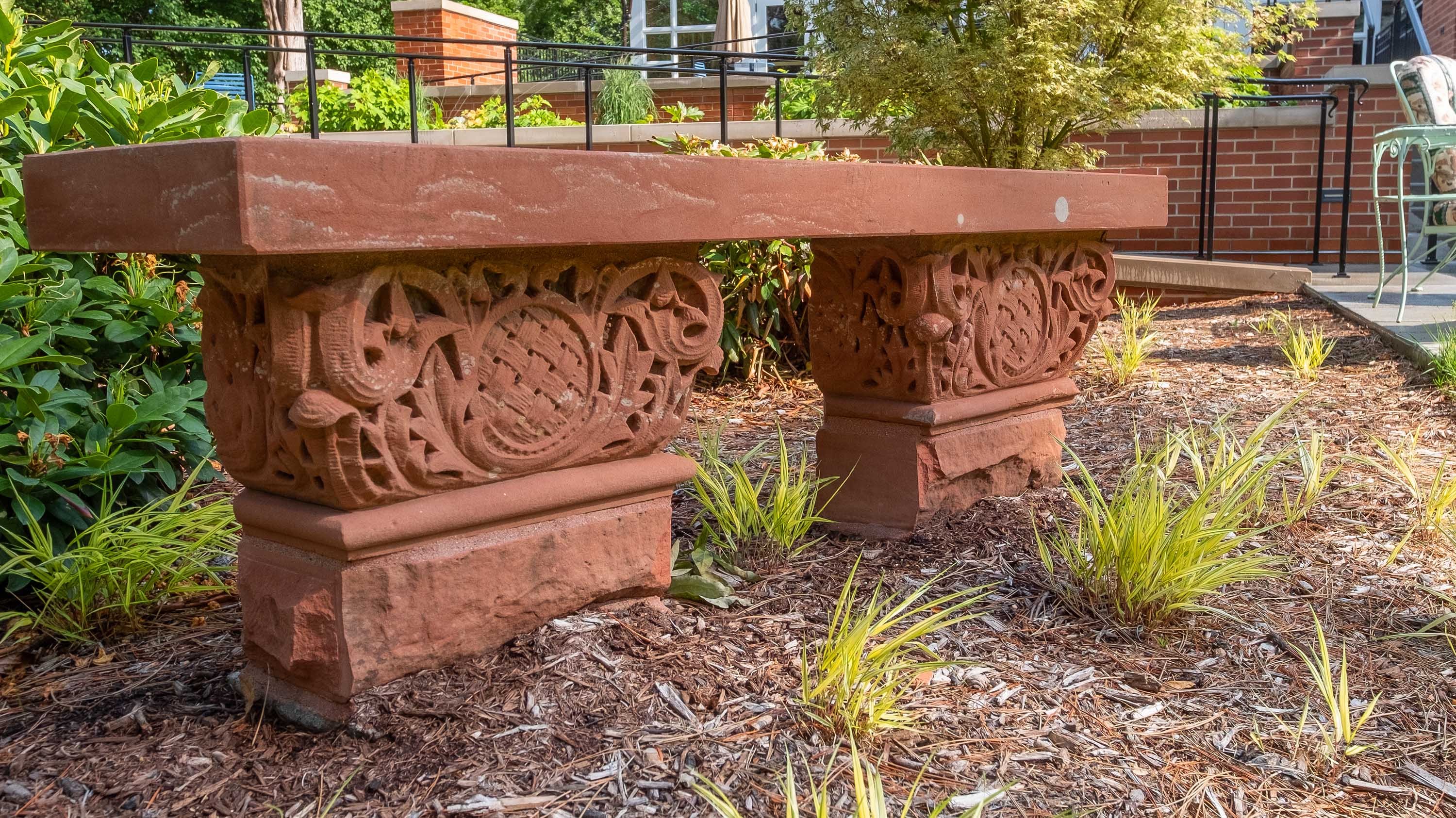 Bench made of red, stonework-laden brick in the backyard of Cowles House