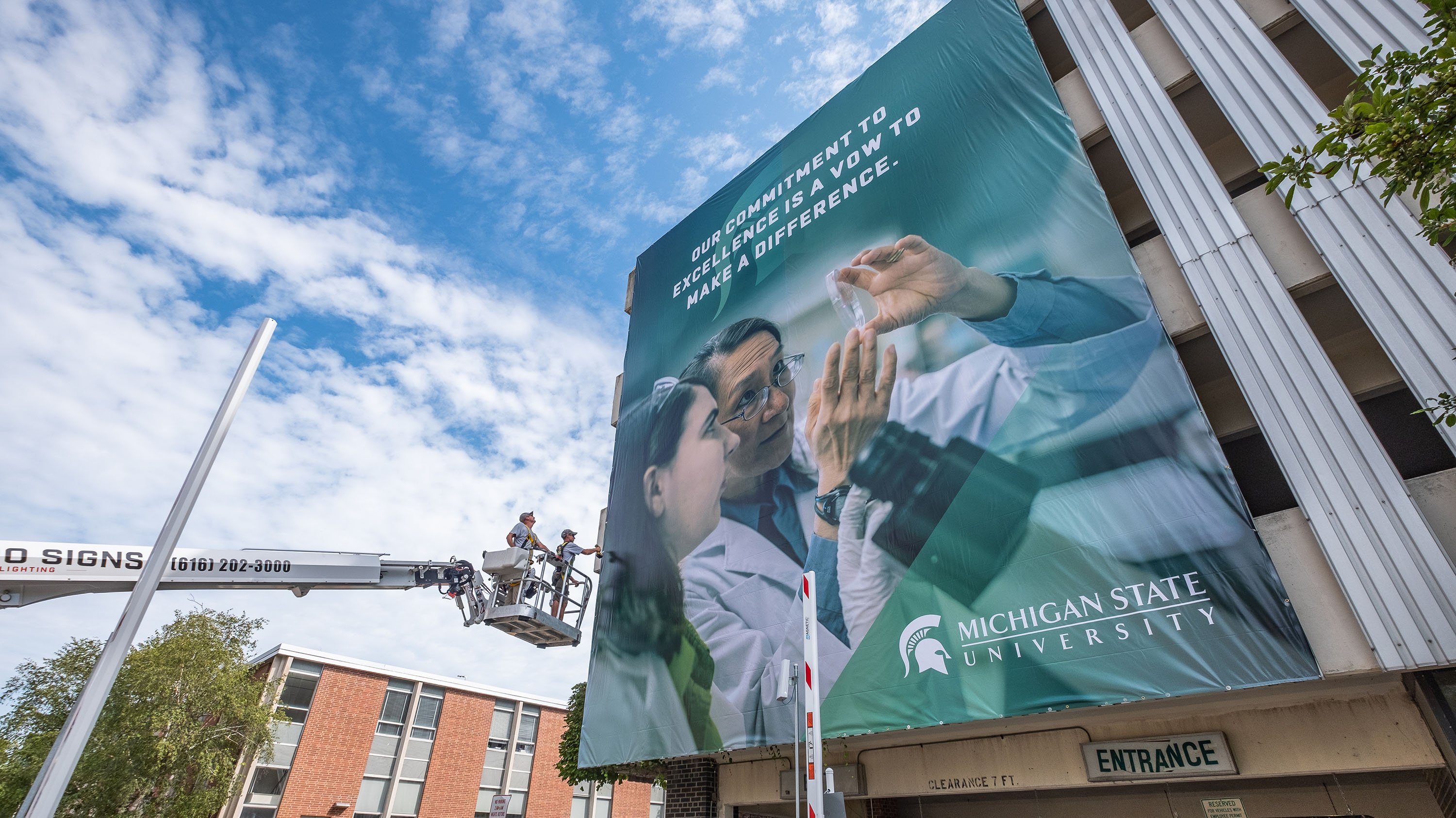Installation of a large banner over an MSU parking ramp