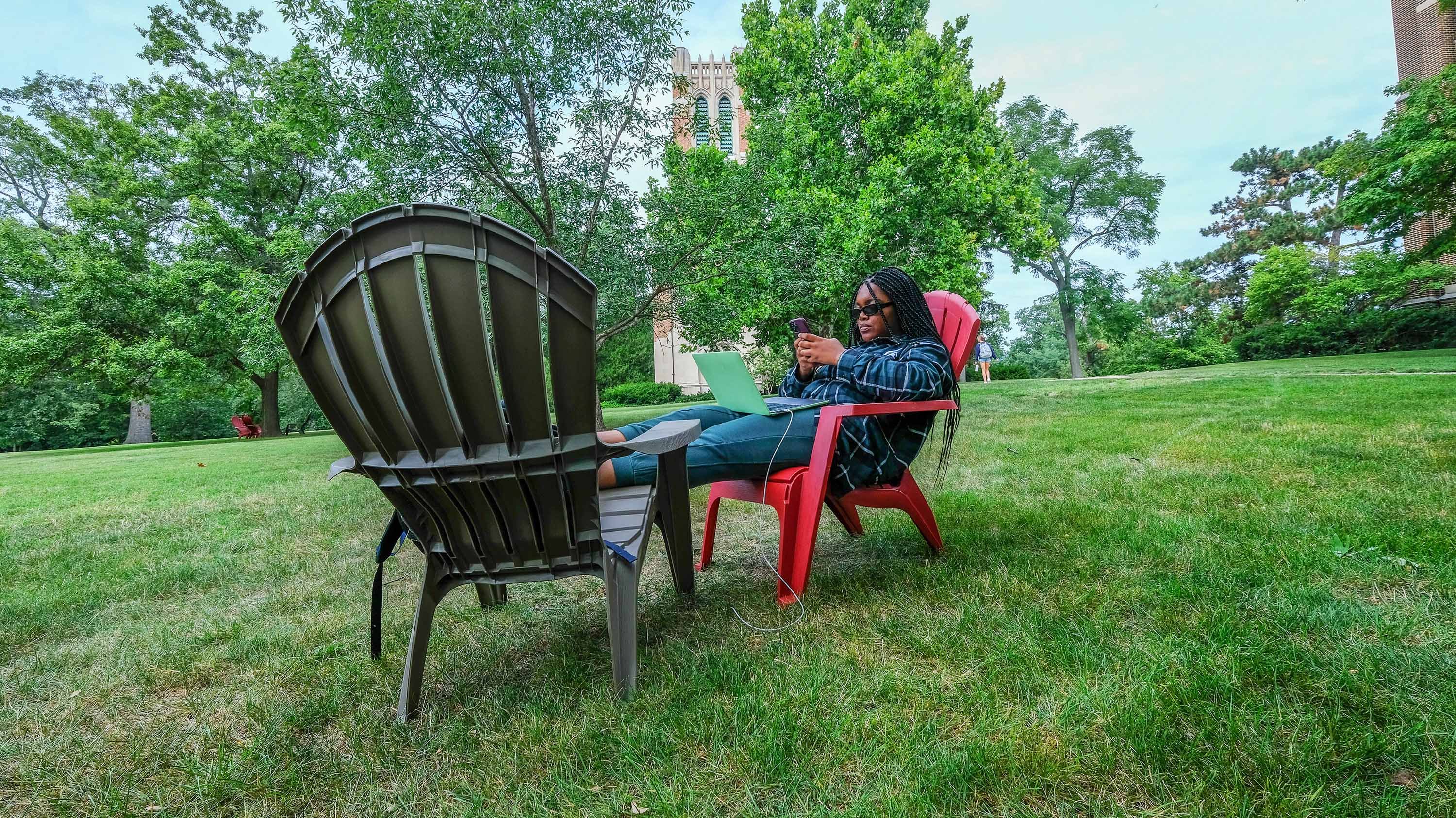 Student sitting in a lawn chair studying