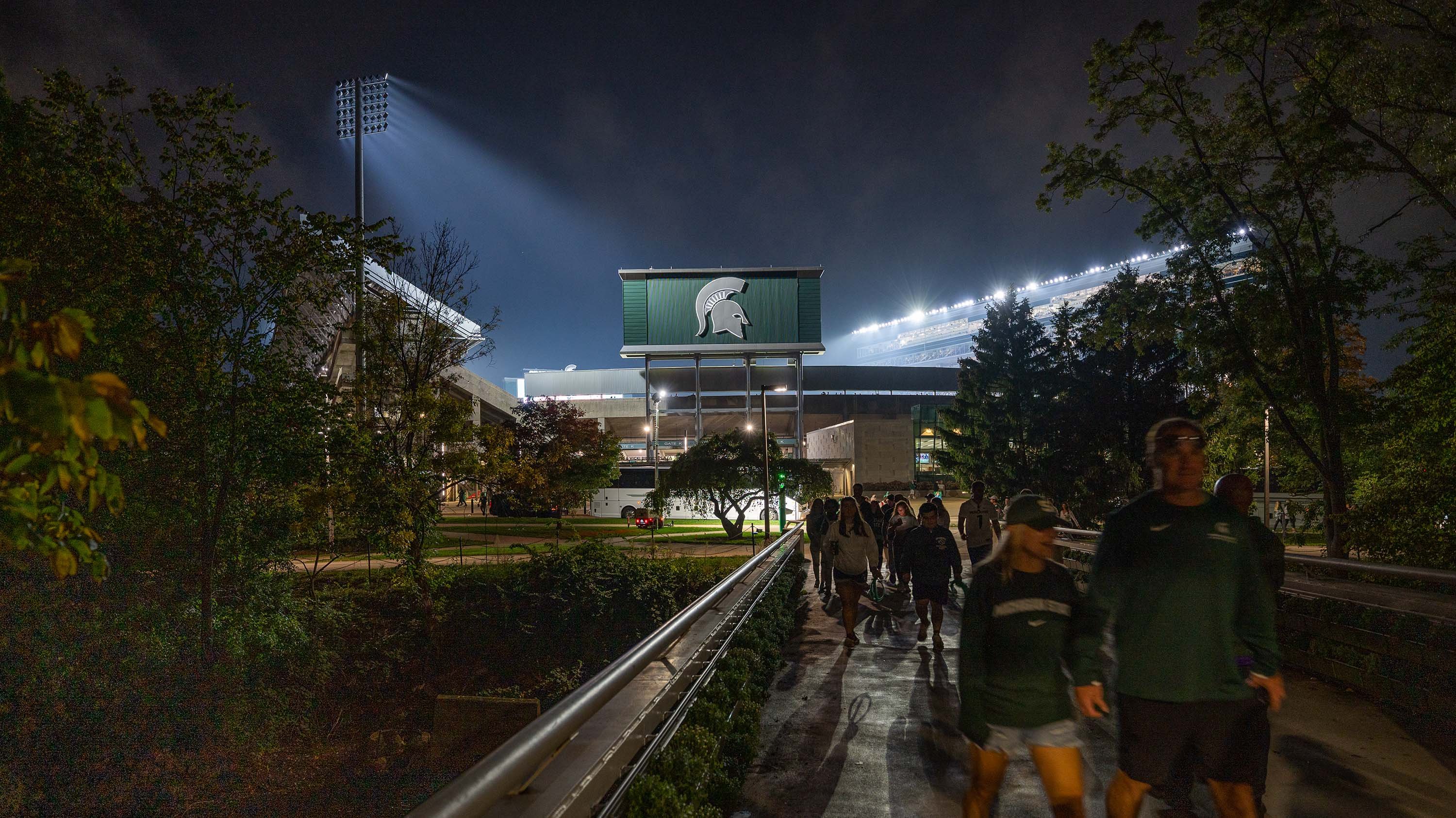 Fans walking on bridge outside of Spartan Stadium after homecoming game