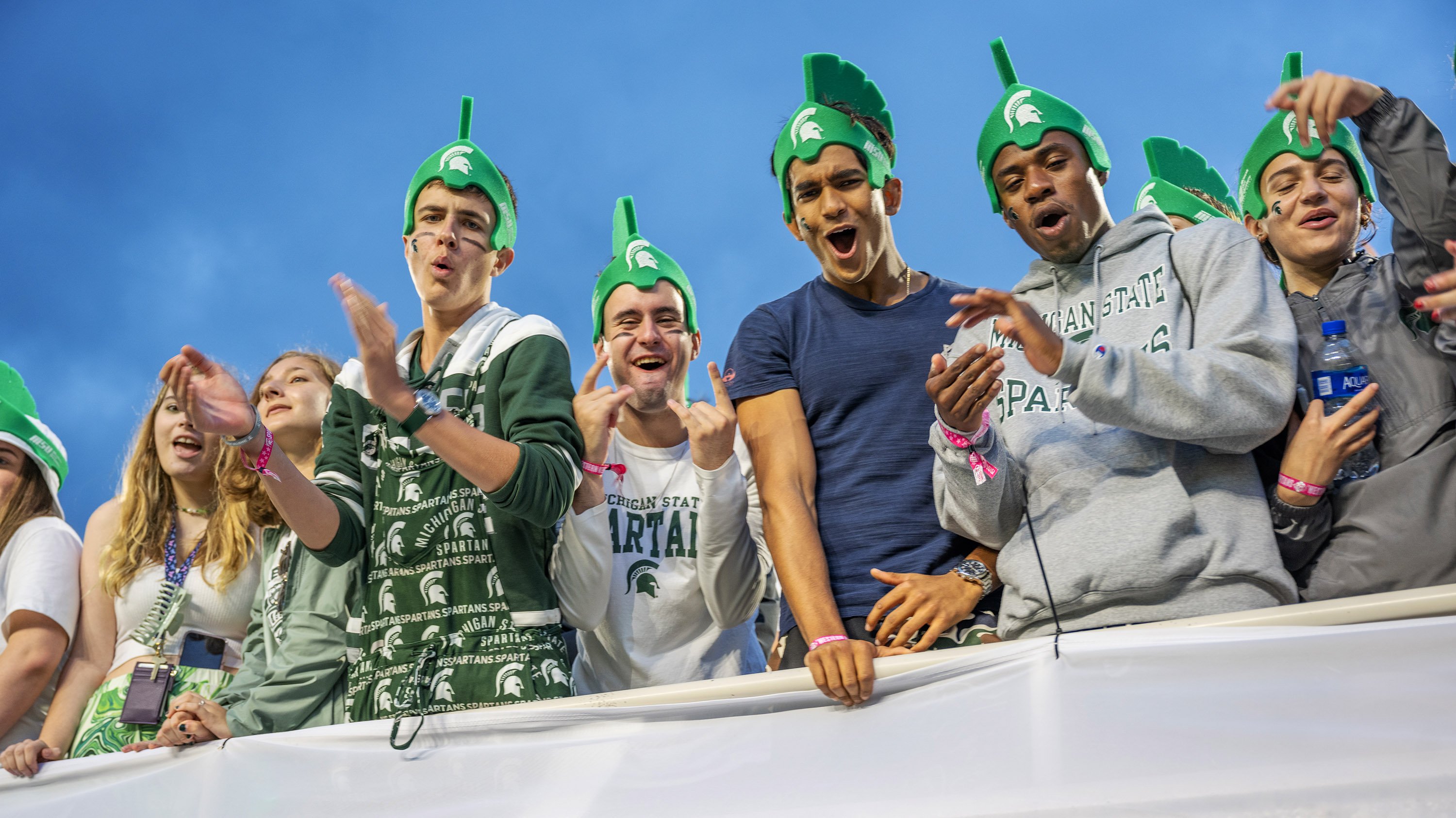 Students cheering while wearing foam Spartan helmets