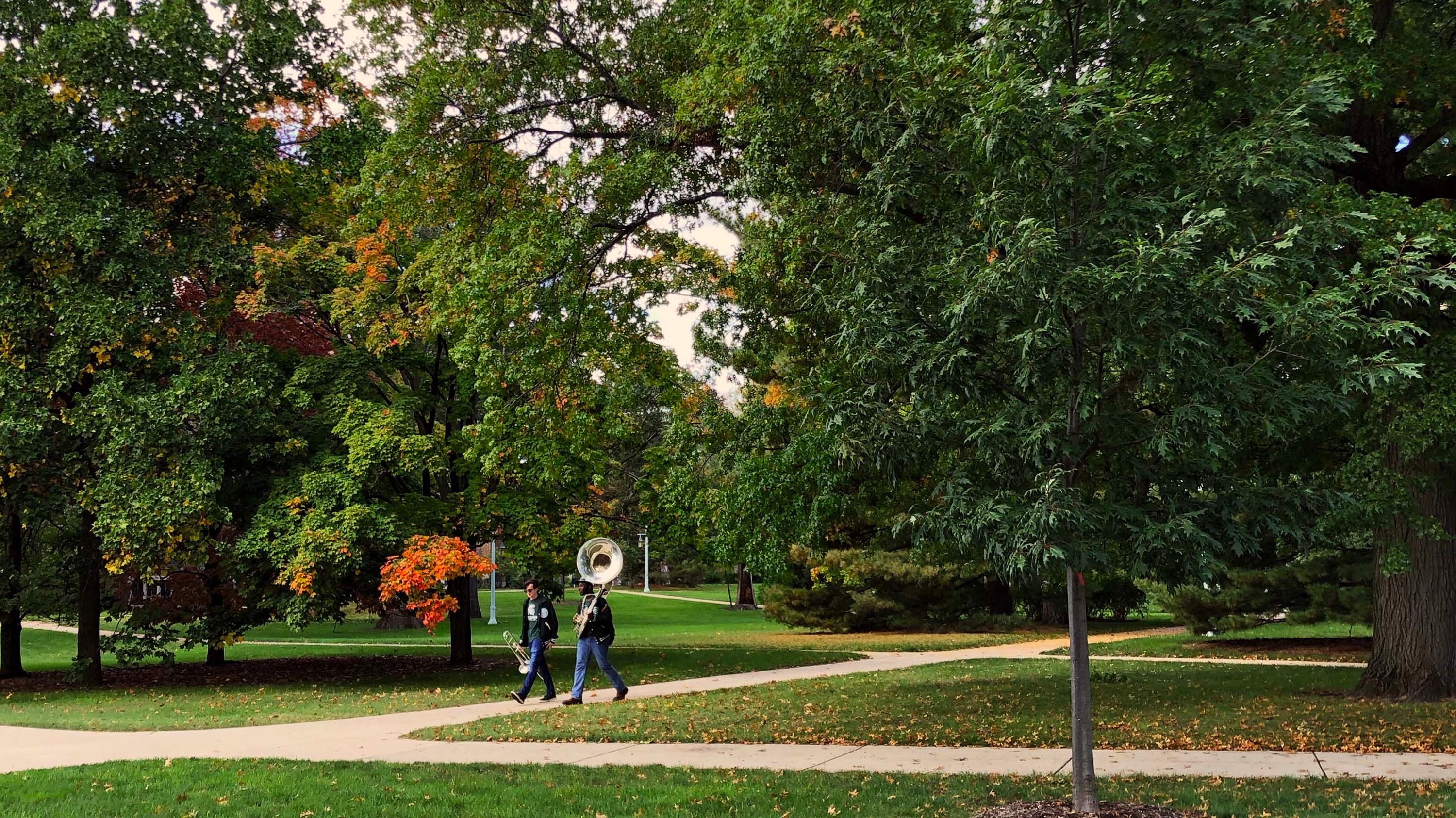 Two marching band students walking on campus