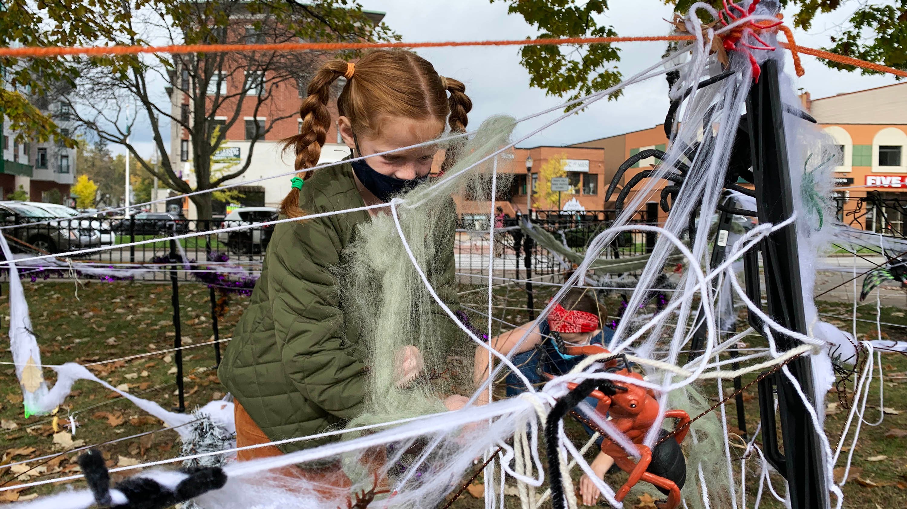 A child interacts with a halloween activity outside the MSU Broad museum