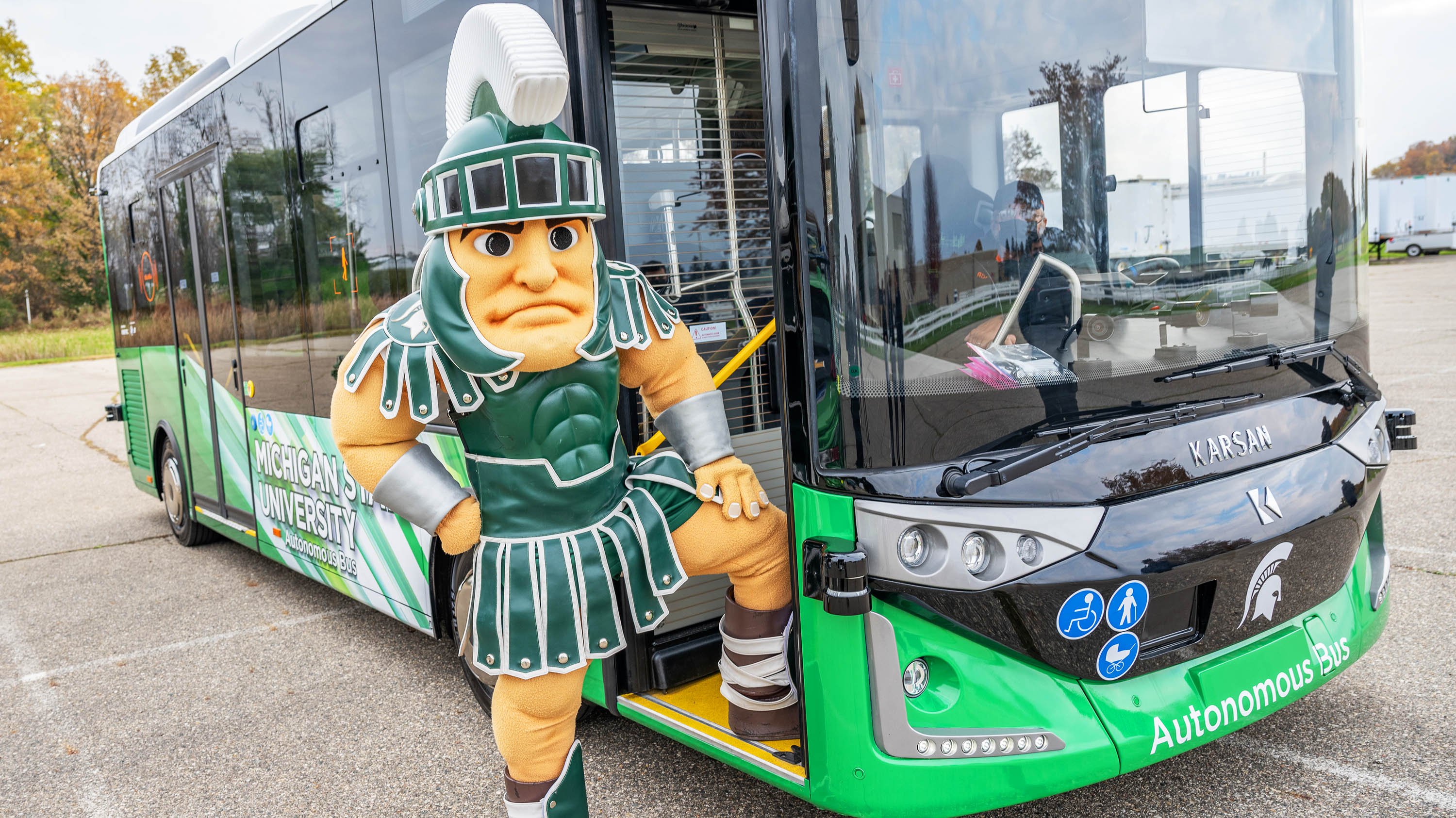 Sparty posing with MSU autonomous bus