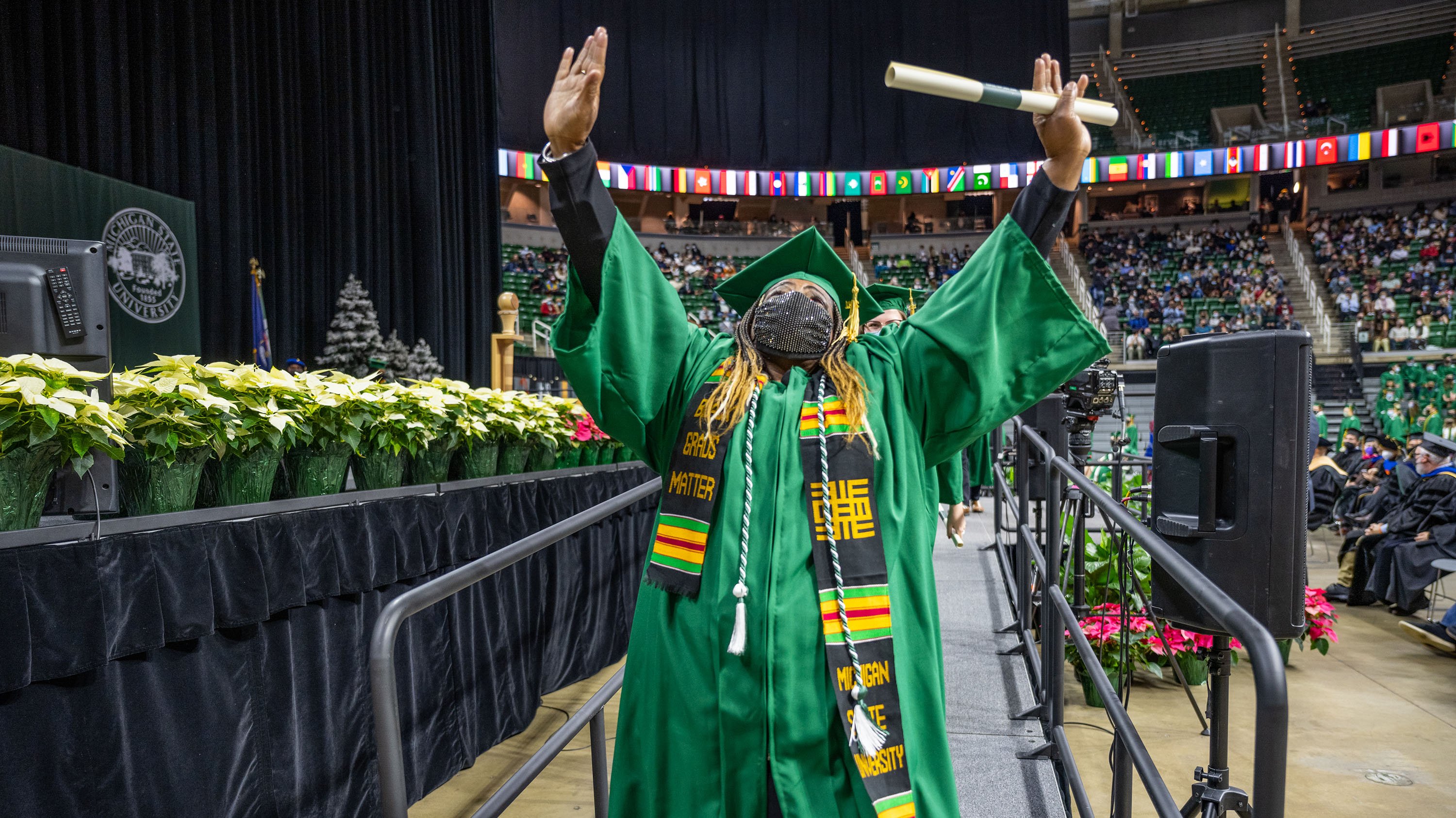 Margery Aimery, MSU employee celebrates after receiving her diploma at the MSU Fall 2021 Undergraduate Commencement, Breslin Student Events Center