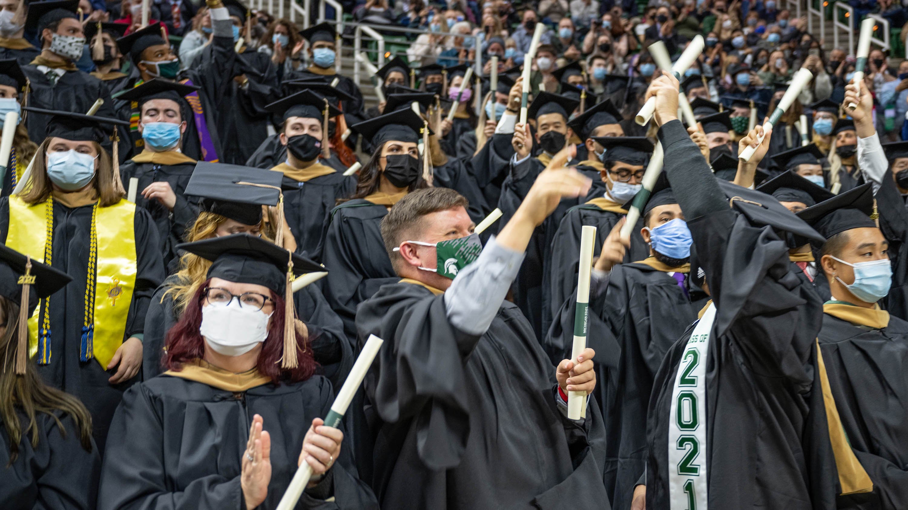 Students with diplomas at fall 2021 graduate degree ceremony