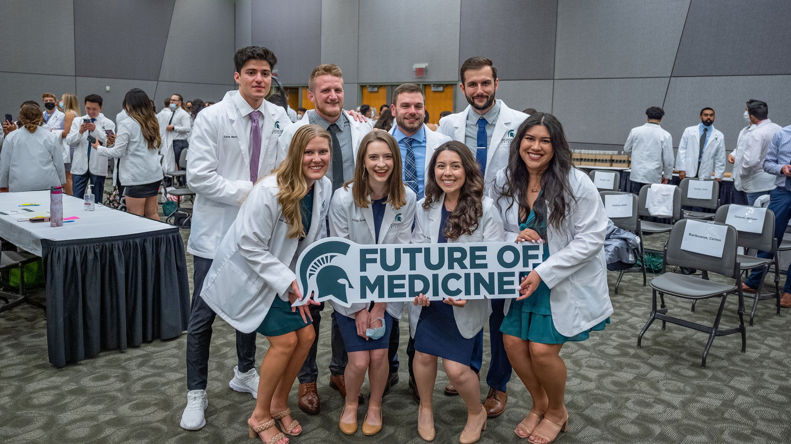 Med students post-White Coat Ceremony, posing with a sign that reads 'future of medicine'