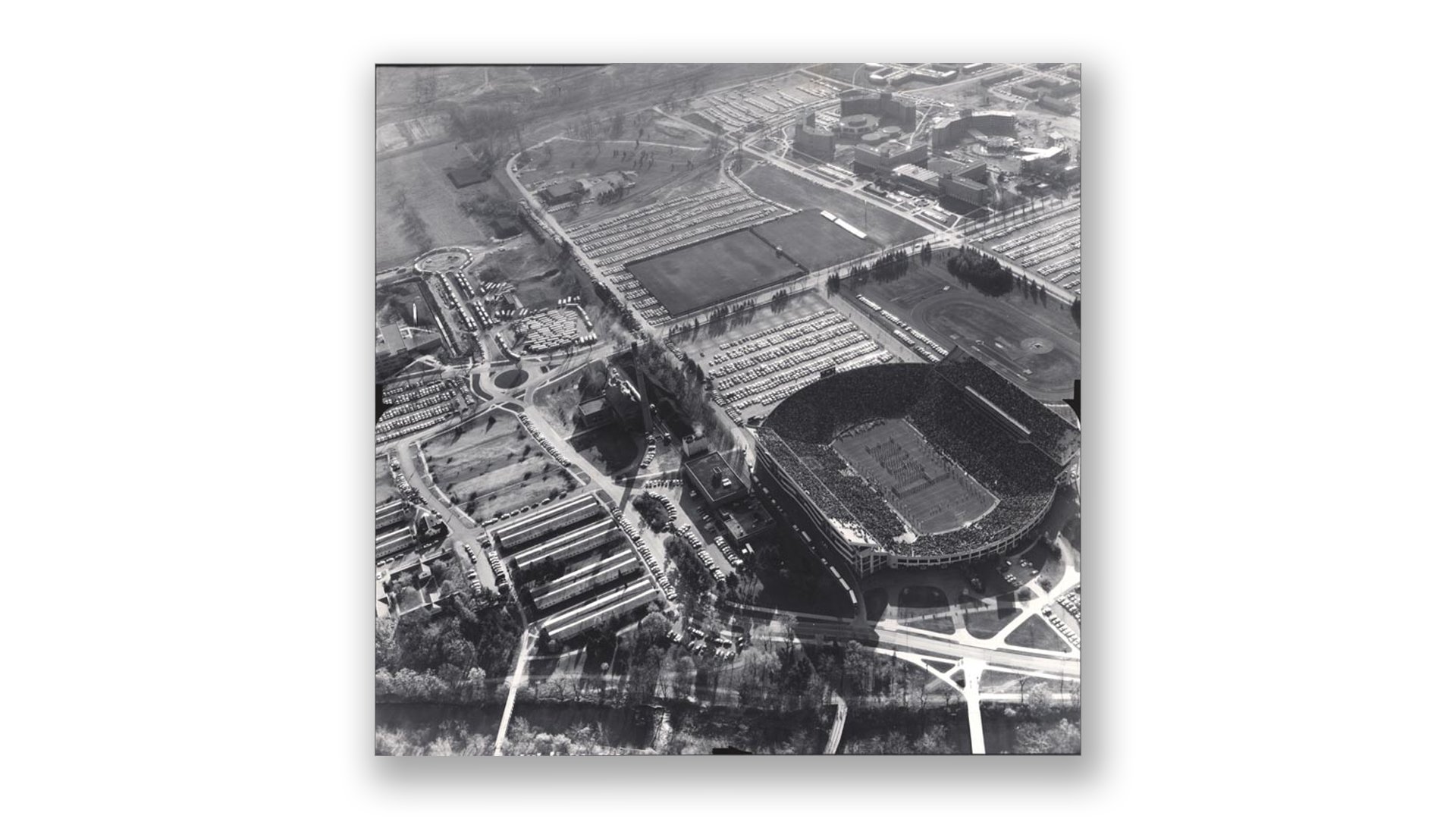 A black-and-white photo from 1962 shows an aerial view of the Shaw Lane Power Plant and Spartan Stadium.