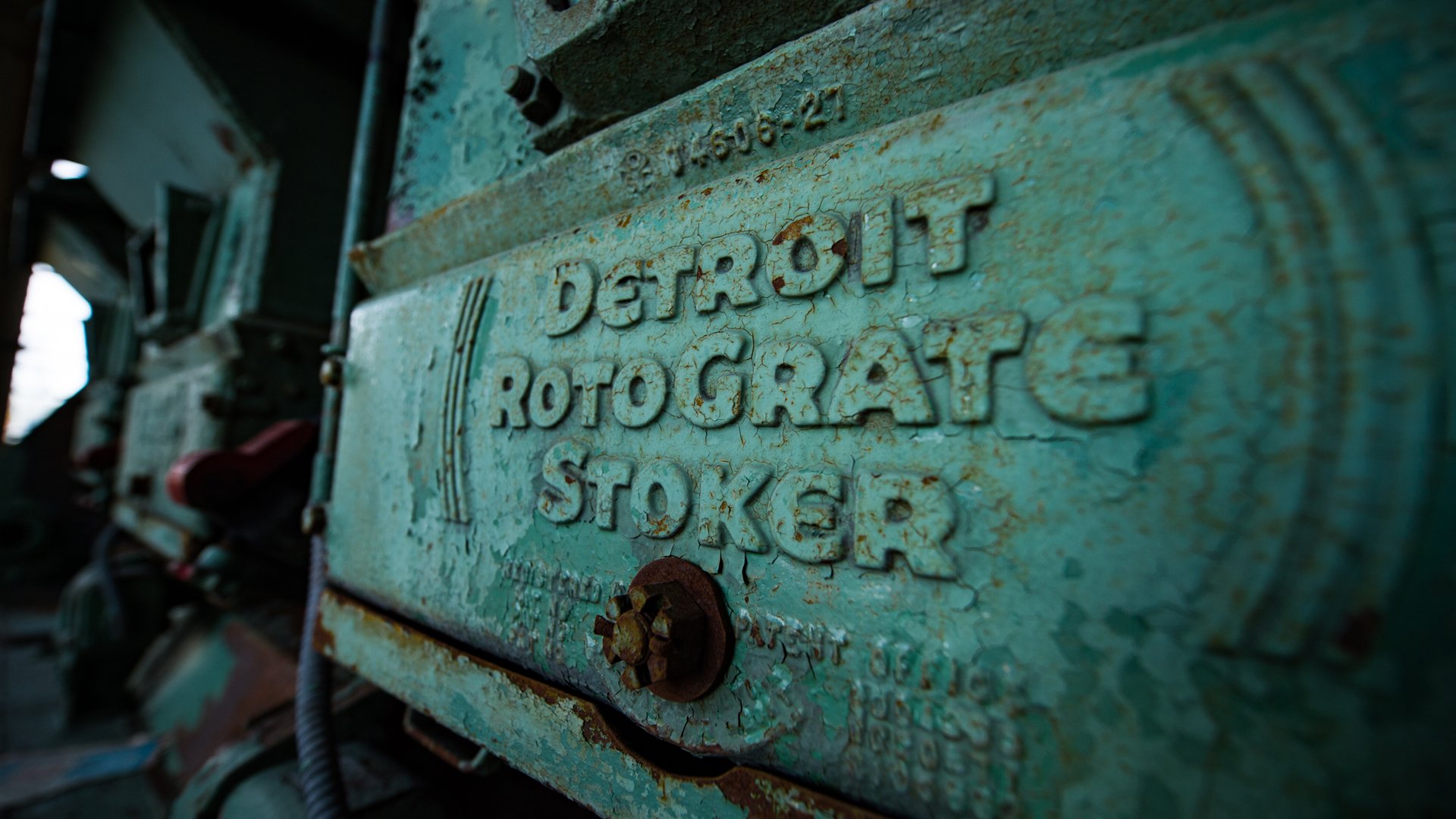 A photograph from inside the Shaw Lane Power Plant in 2018 shows equipment that says 'Detroit Rotograte Stoker.'