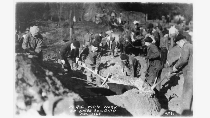 Photo of people digging. Writing reads 'M.A.C Men work on Union Building Nov. 1923'