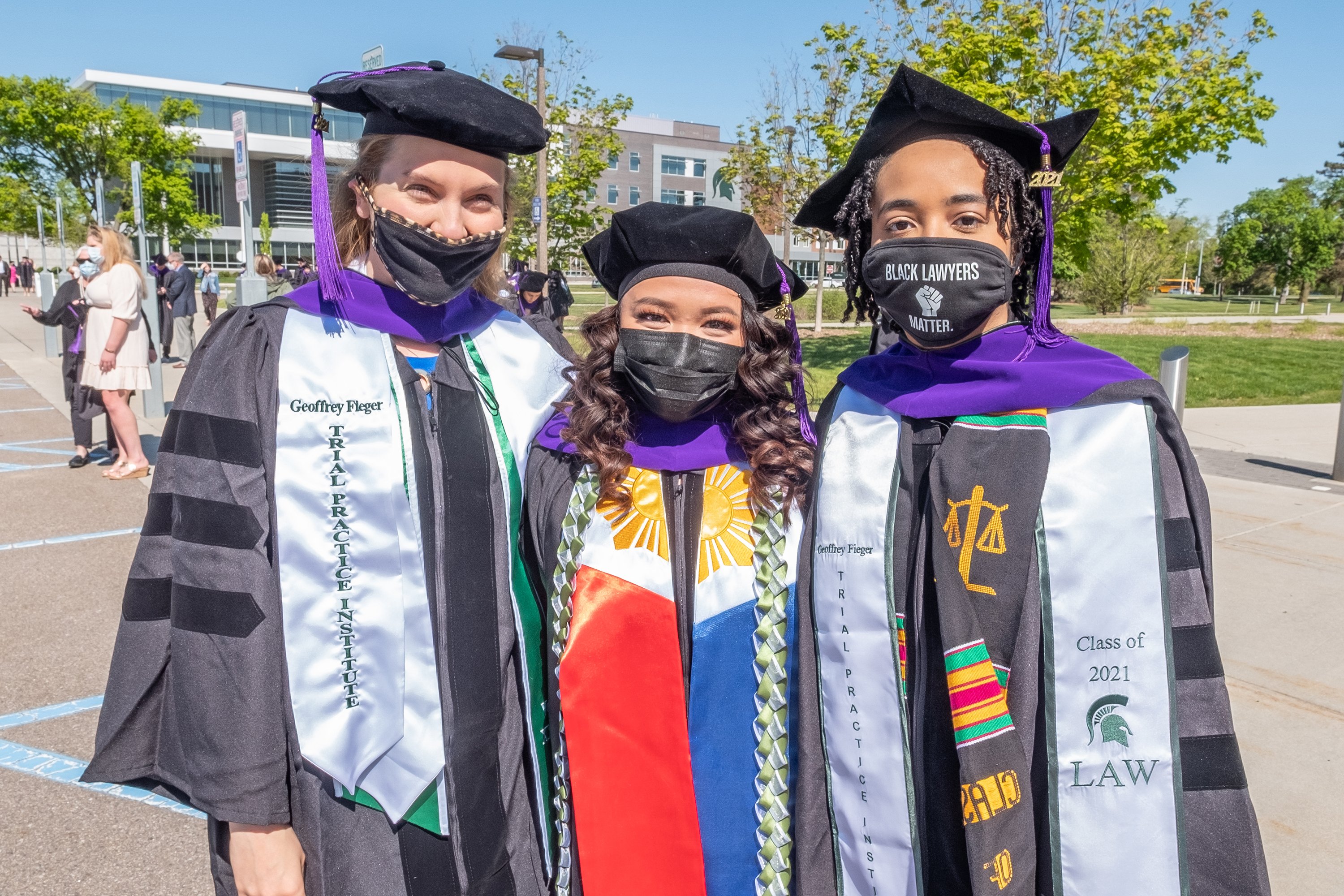 three graduates in cap and gowns