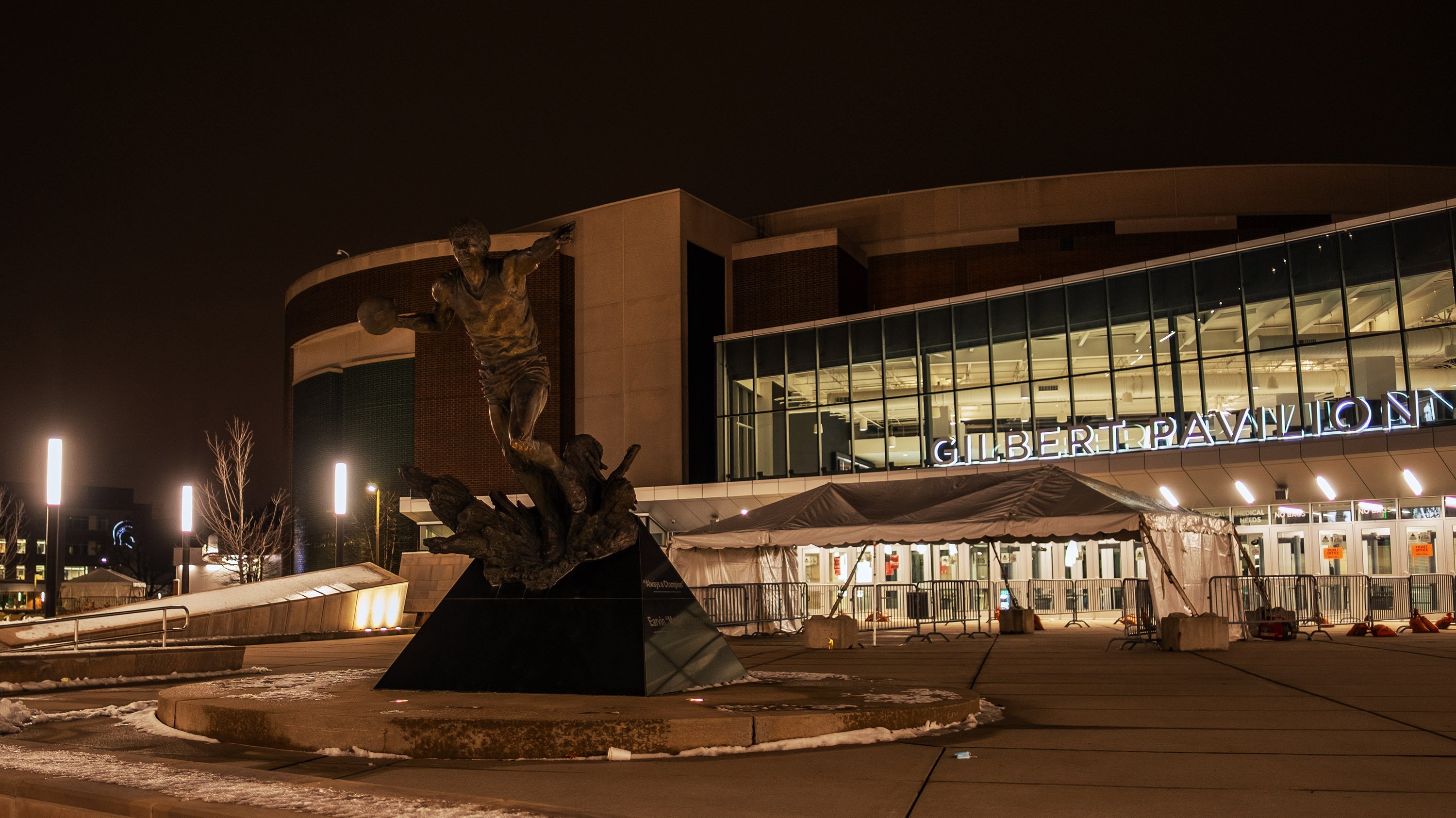 Magic Johnson statue at the Jack Breslin Student Events Center, Gilbert Pavilion entrance on a winter night.