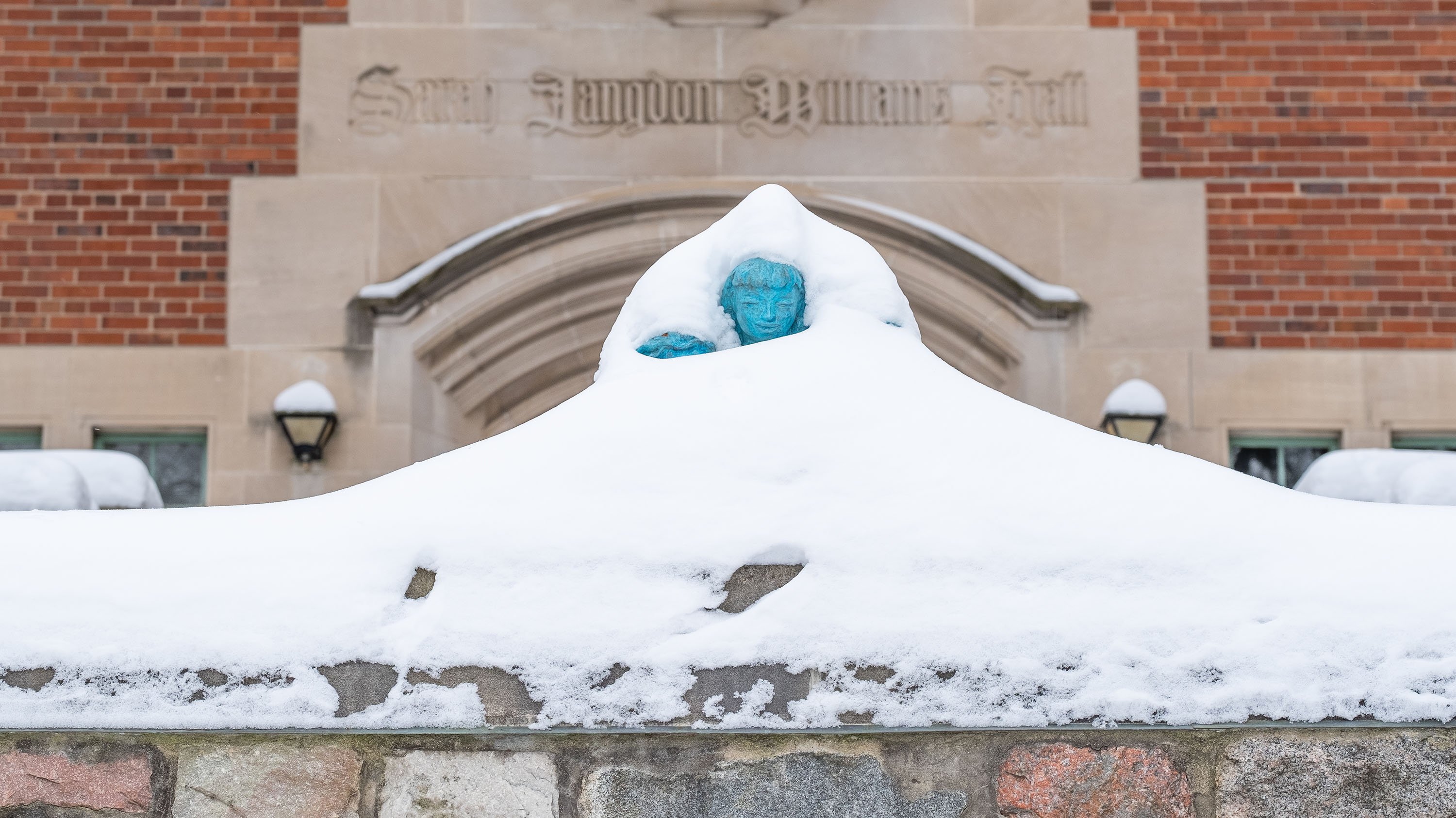 'Children Reading' sculpture in front of Williams hall, nearly covered in snow