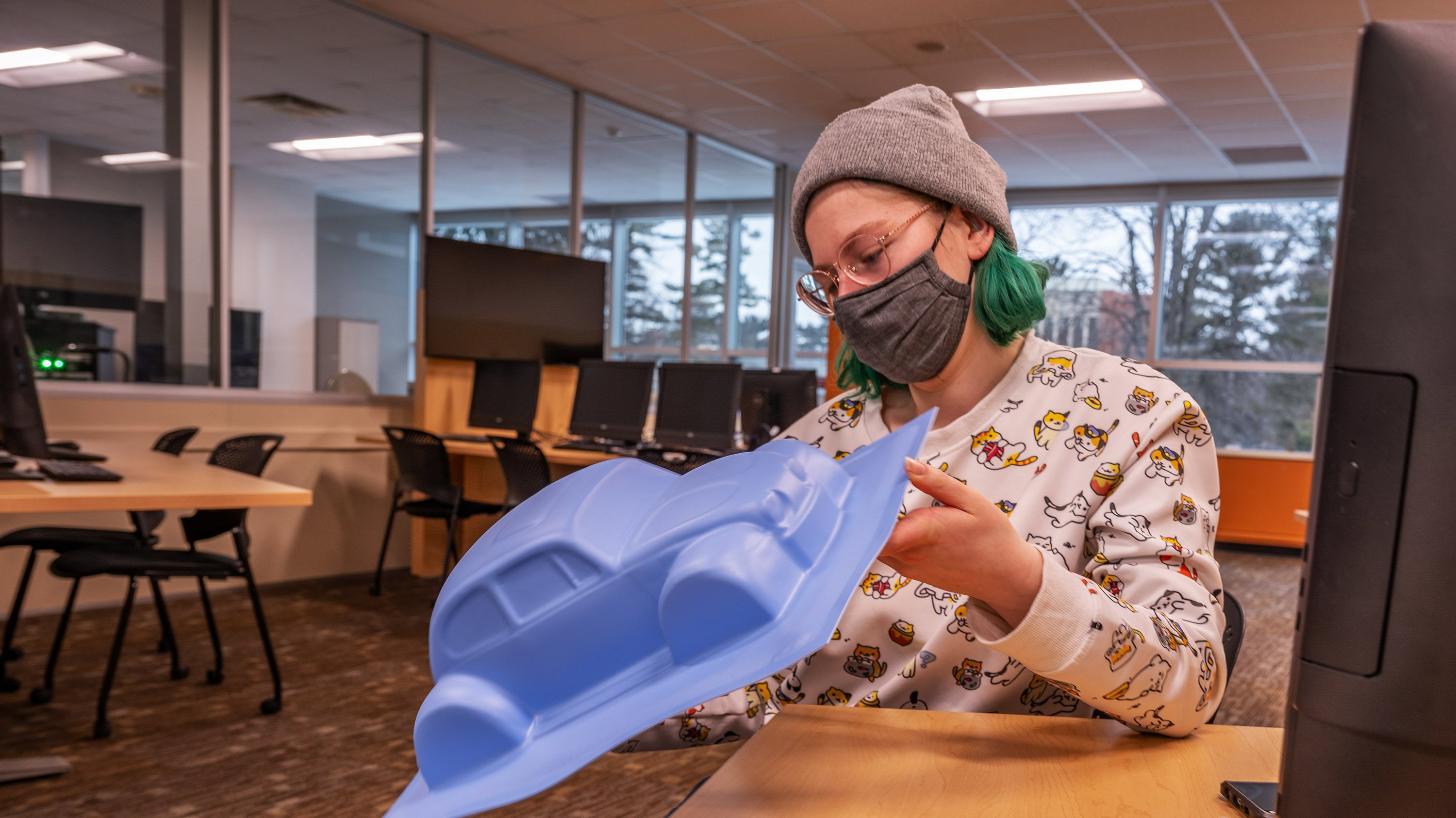 Student holding plastic mold of a car