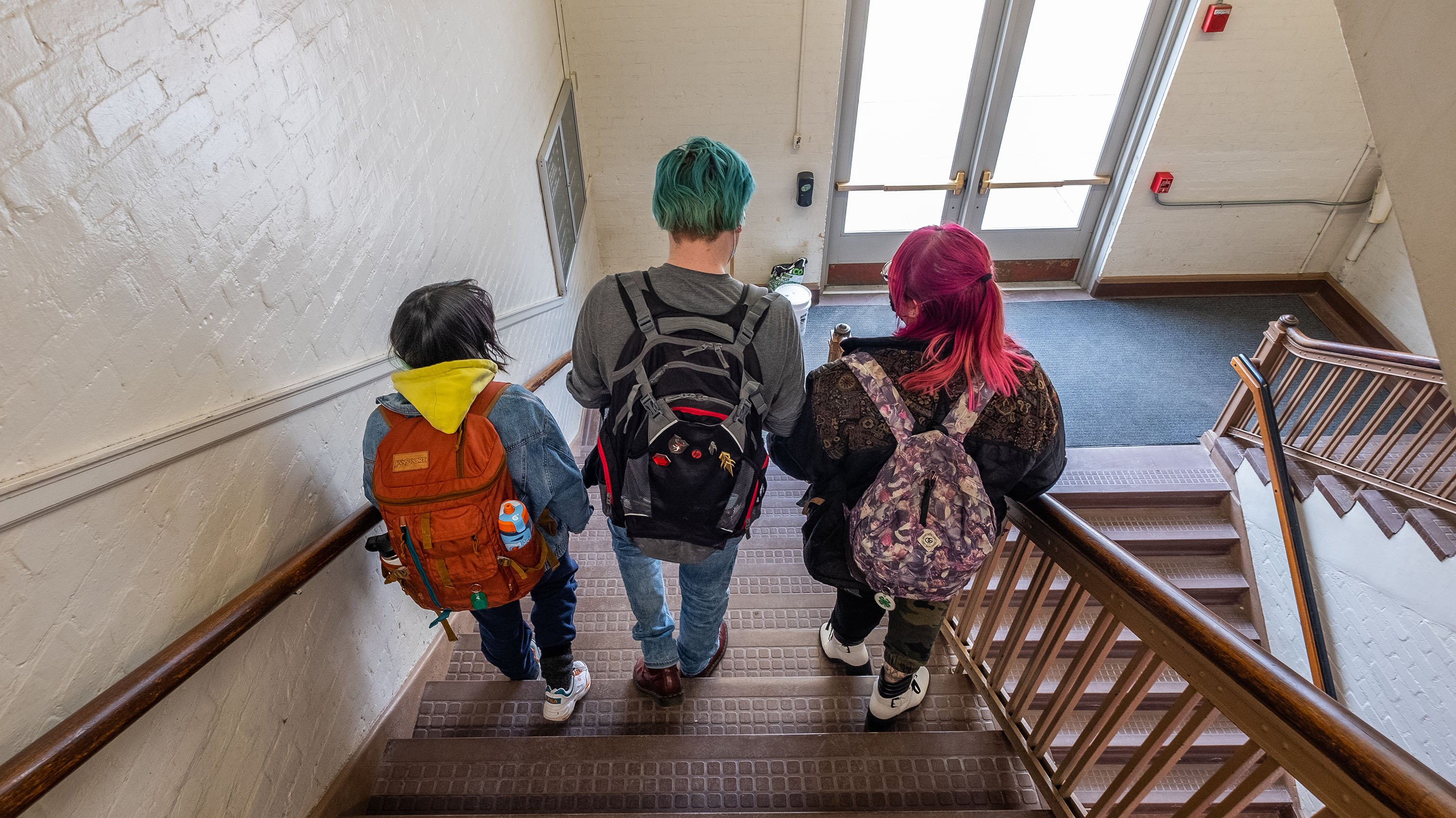 Three students walking down stairs in Olds Hall