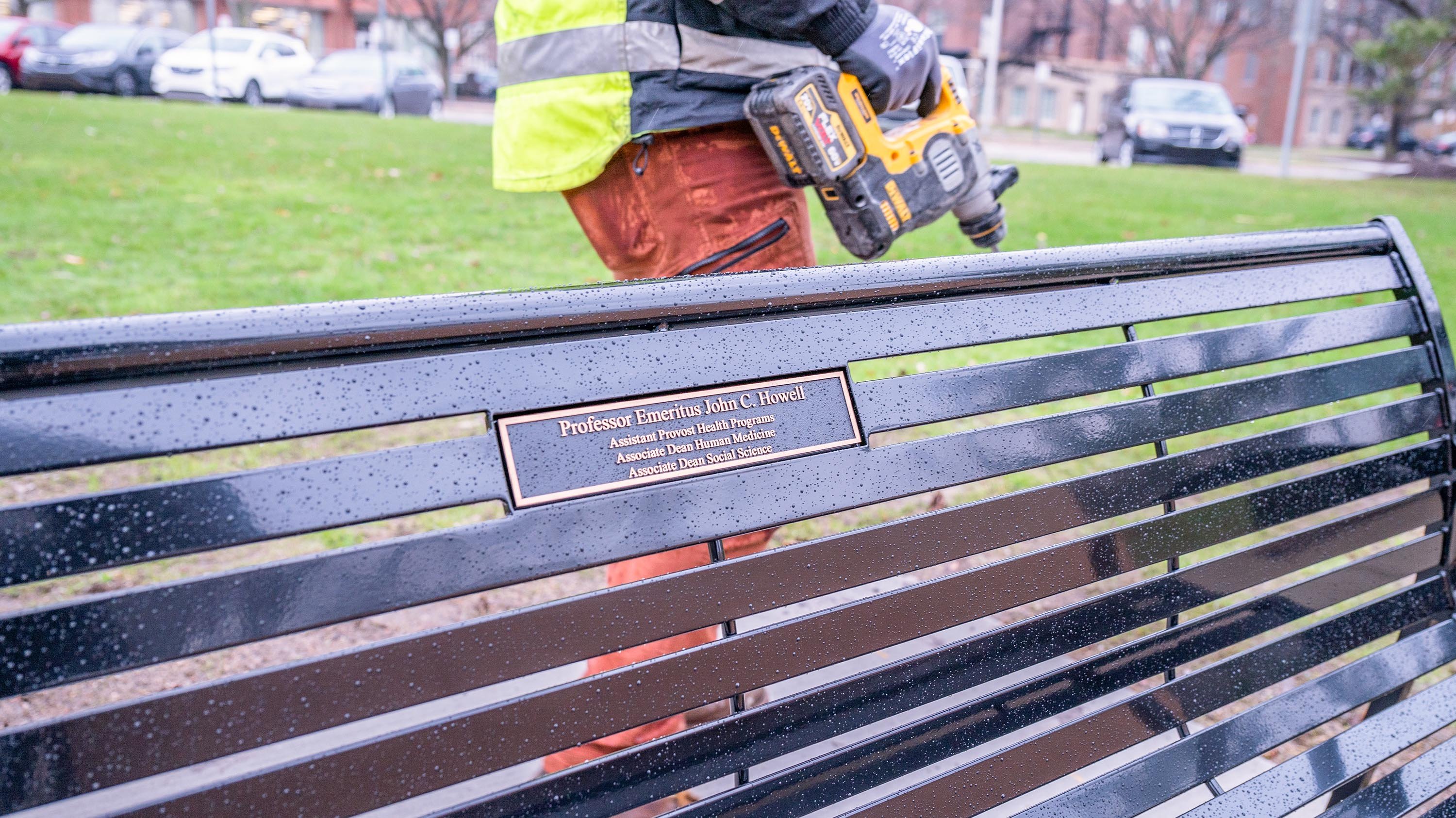 IPF crewmember installing memorial bench for Professor Emeritus John C. Howell