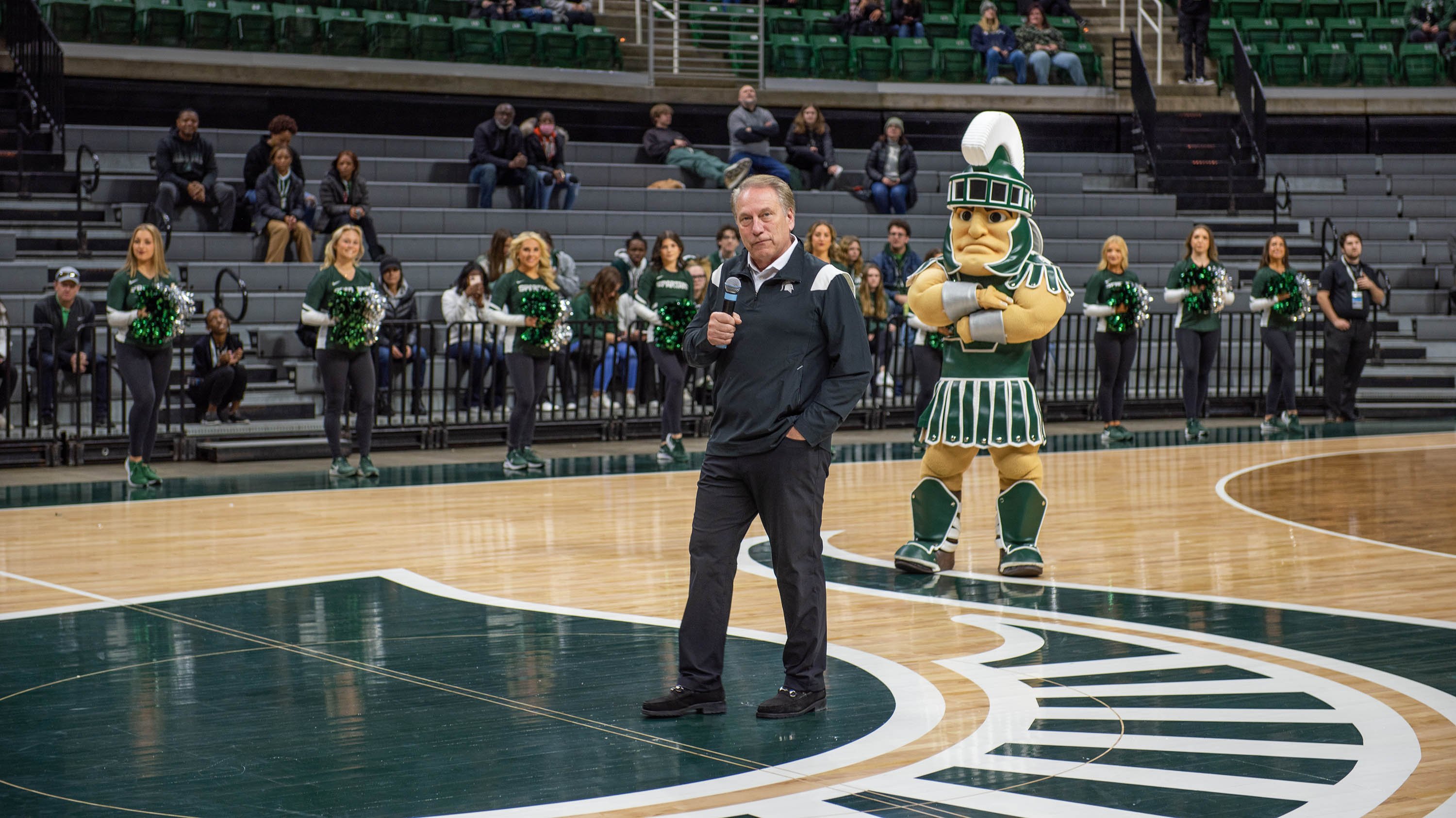 Tom Izzo speaks at the pep rally at MSU Admissions Admitted Students Day, with Sparty behind him