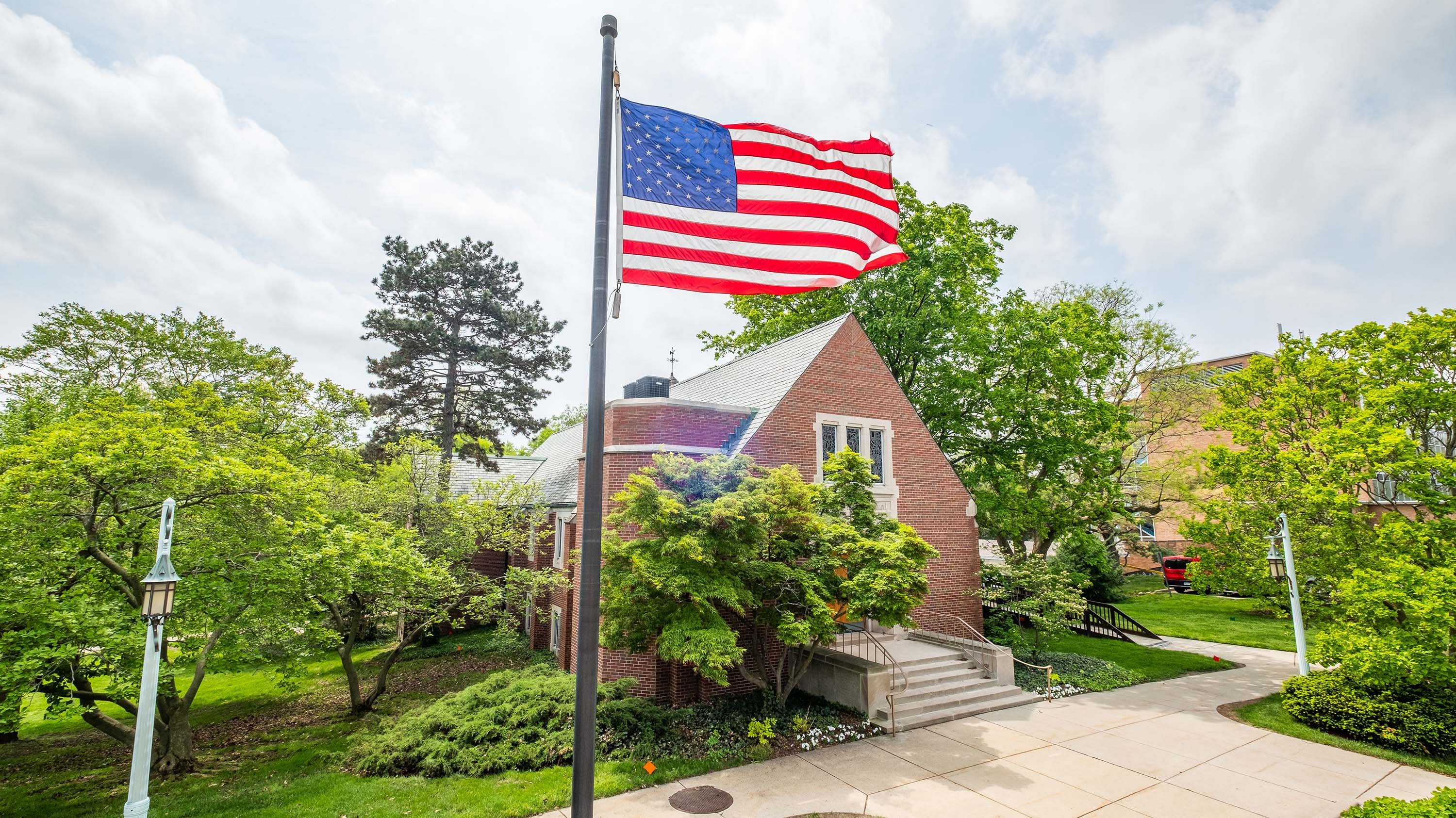 American flag waving in front of MSU Alumni Memorial Chapel
