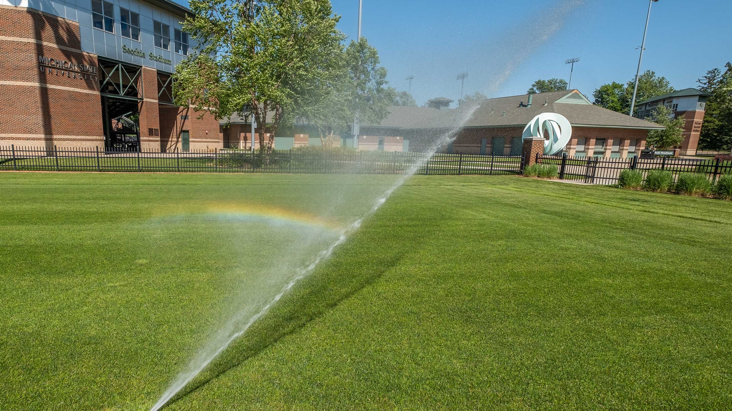 Rainbow created by sprinkler in soccer field