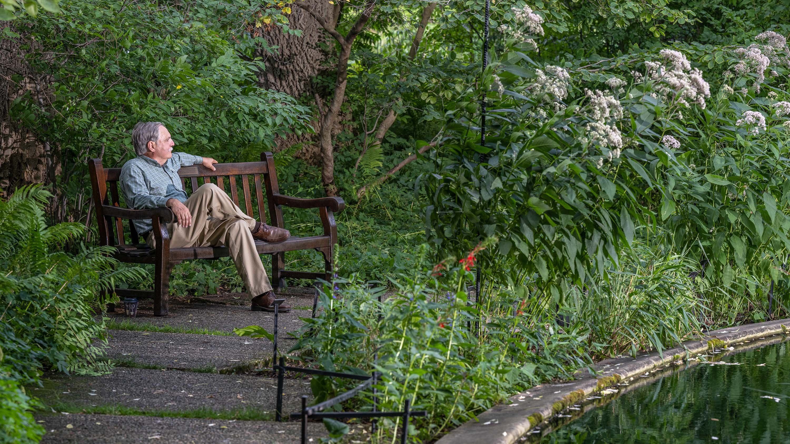 Frank Telewski sitting on a bench in Beal Botanical Garden