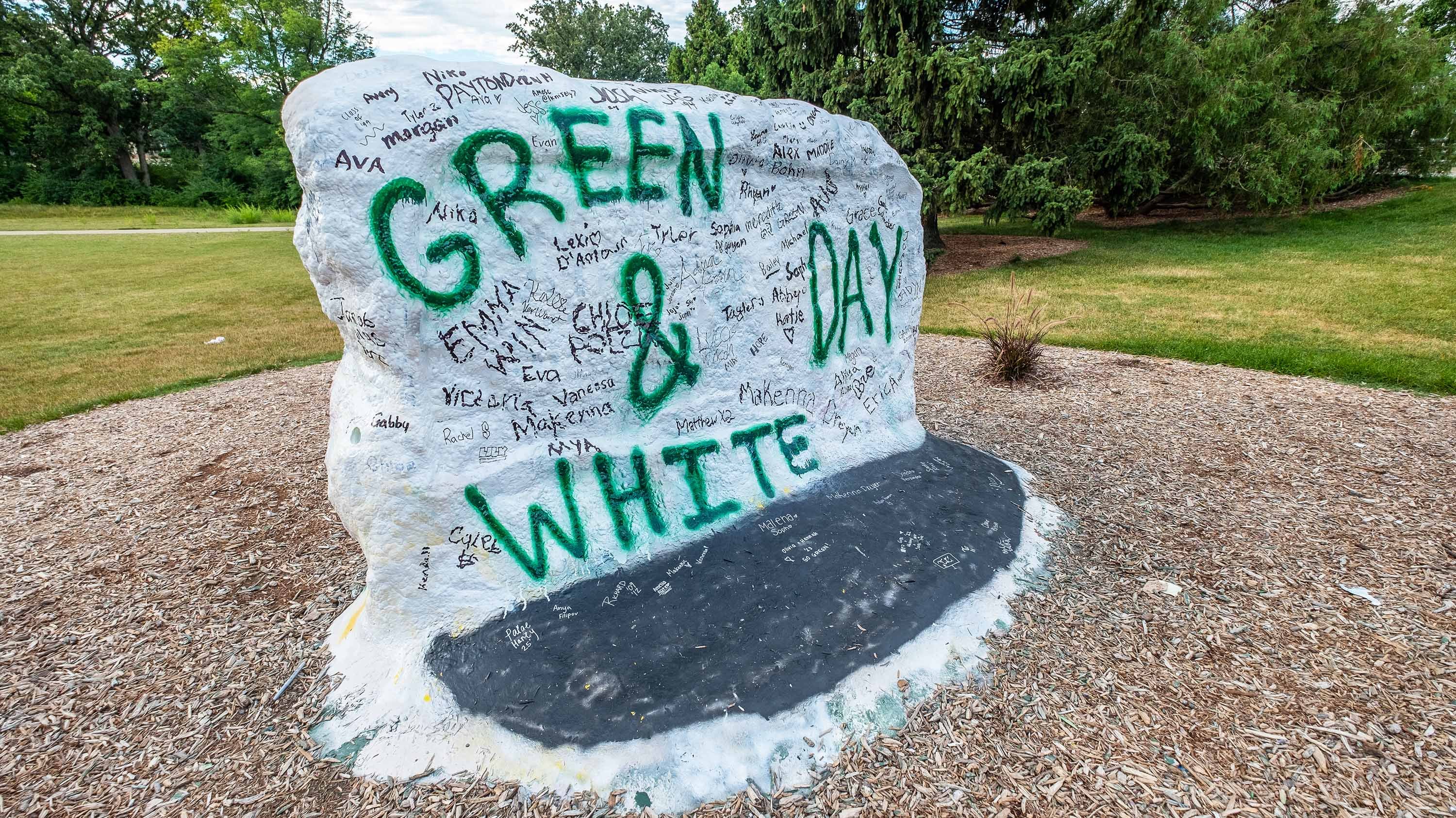 MSU Rock with Green and White Day painted on it, as well as many names written in permanent marker