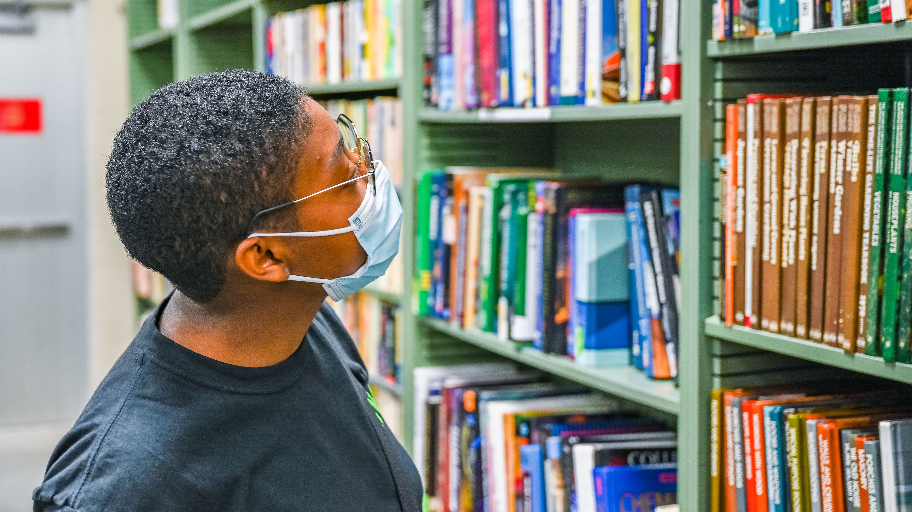 Person looking at the books section of the MSU Surplus Store