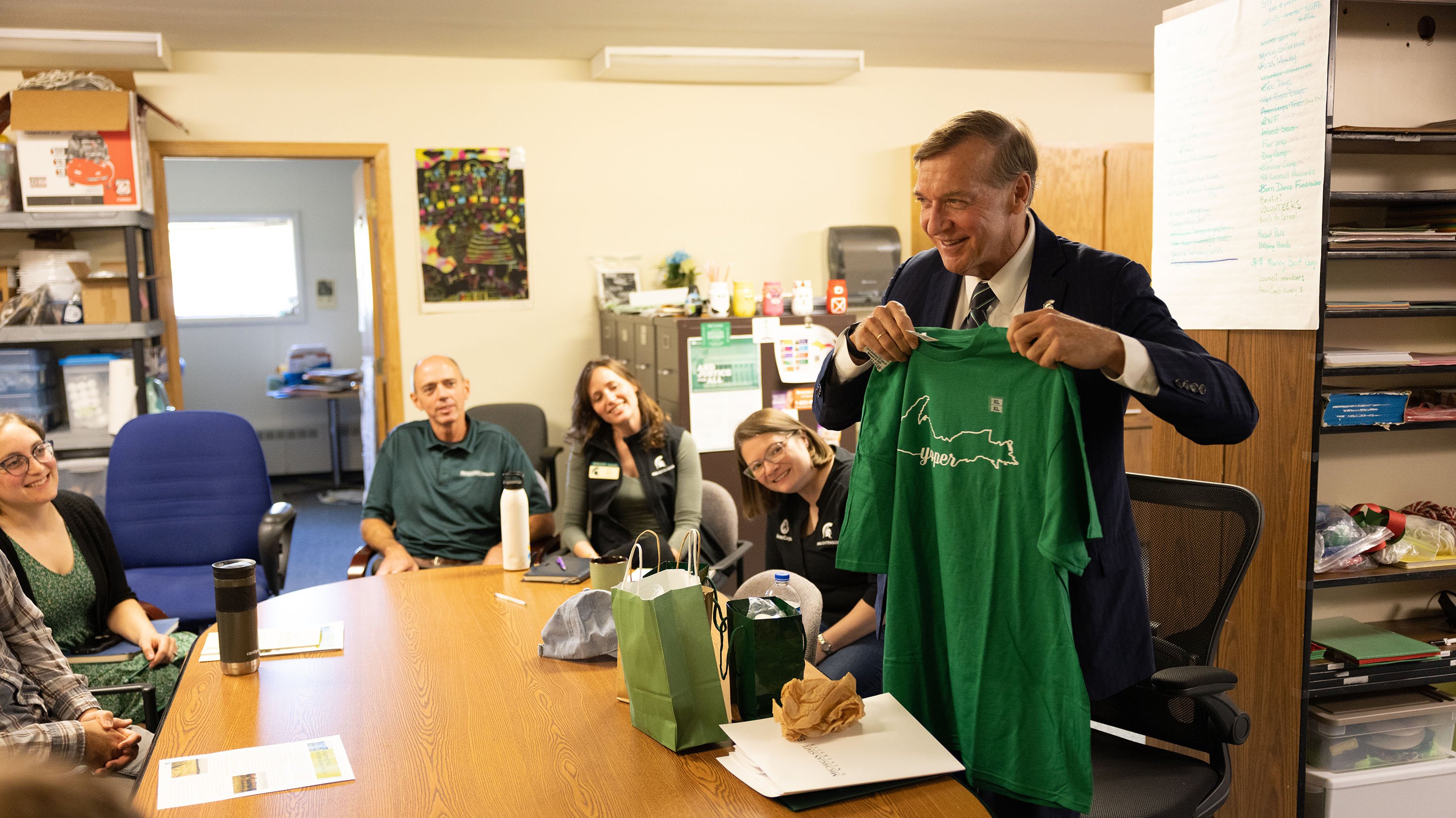 At the MSU?s Marquette County Extension Office in Negaunee, President Stanley meets with staff members and is officially welcomed as a ?yooper? with a fun T-shirt that displays the title. 