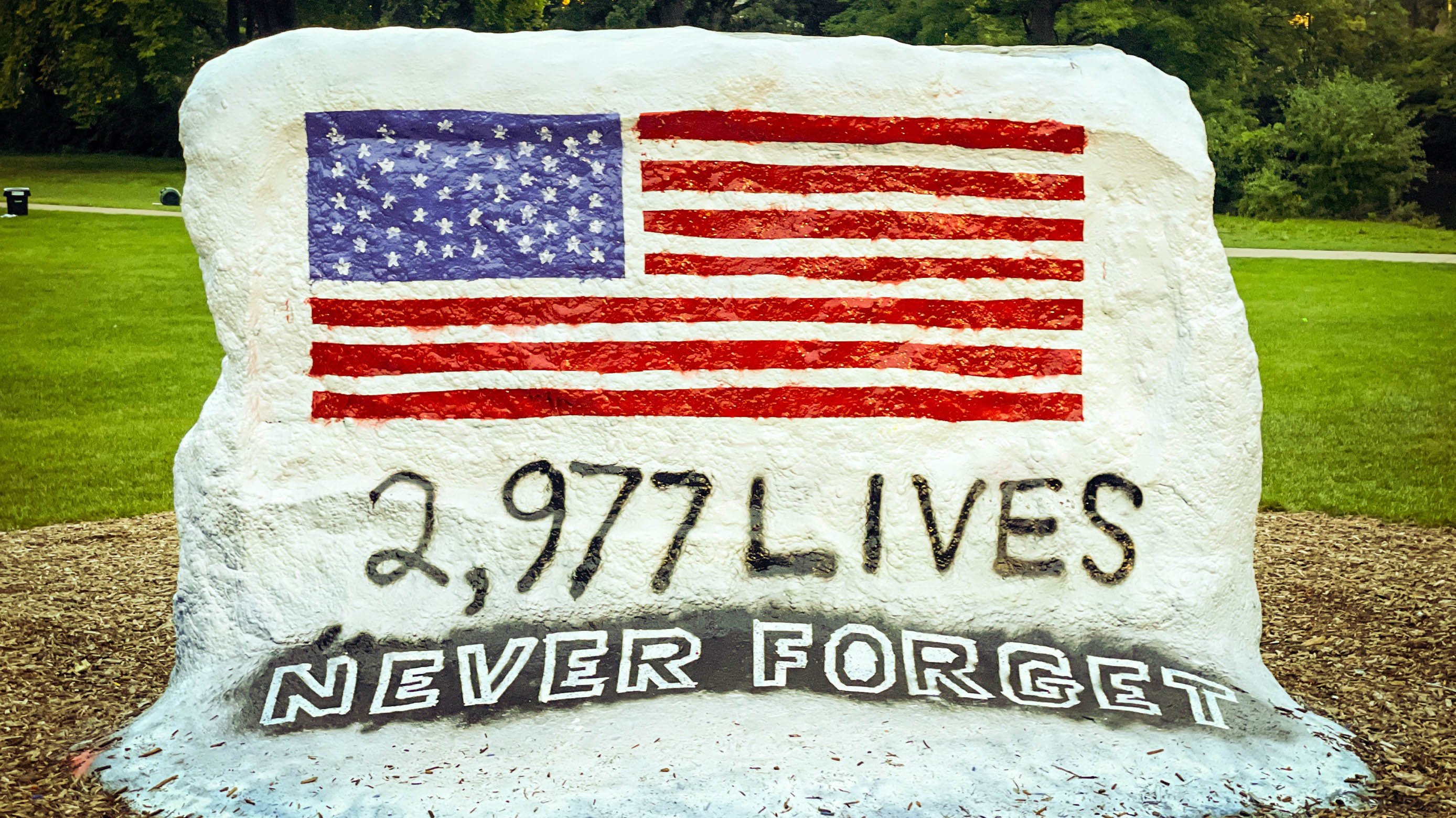 MSU Rock painted with American flag and text: '2,977 lives; never forget'