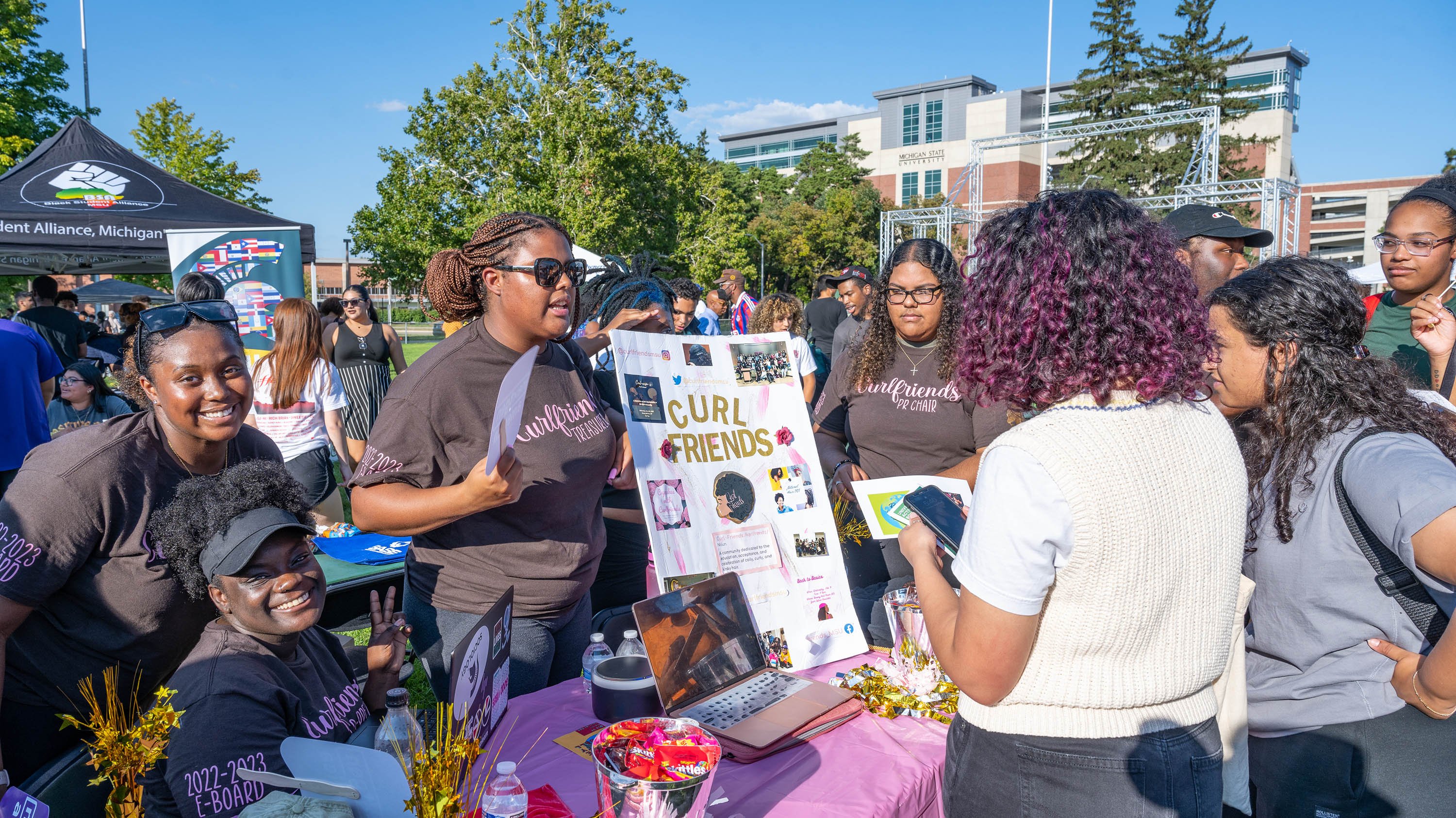 Students at 'Curl Friends' student organization table during Spartan Remix