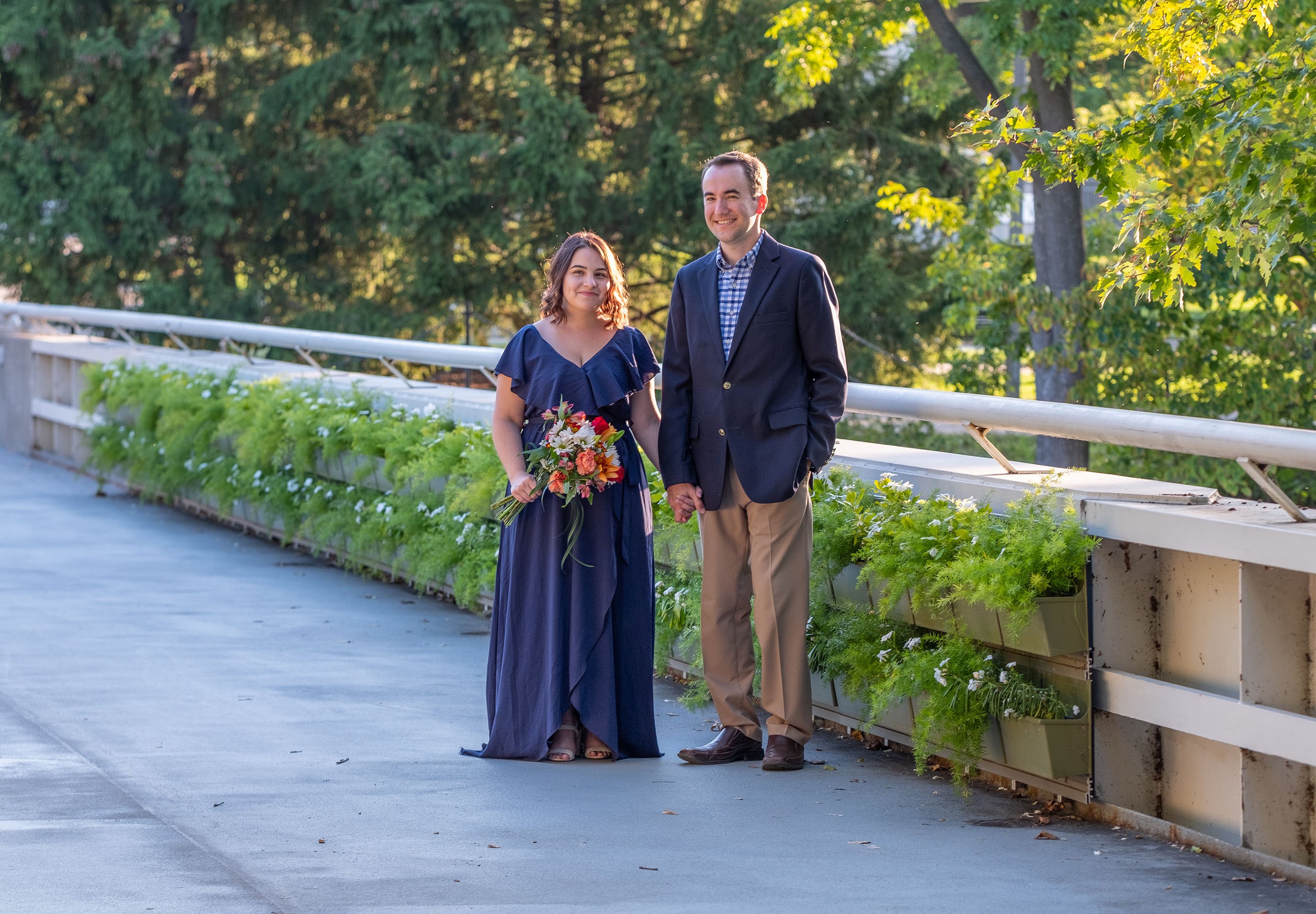 Alumni Matthew Auvenshine and Theresa Guarino take engagement photos along the MSU Library bridge.