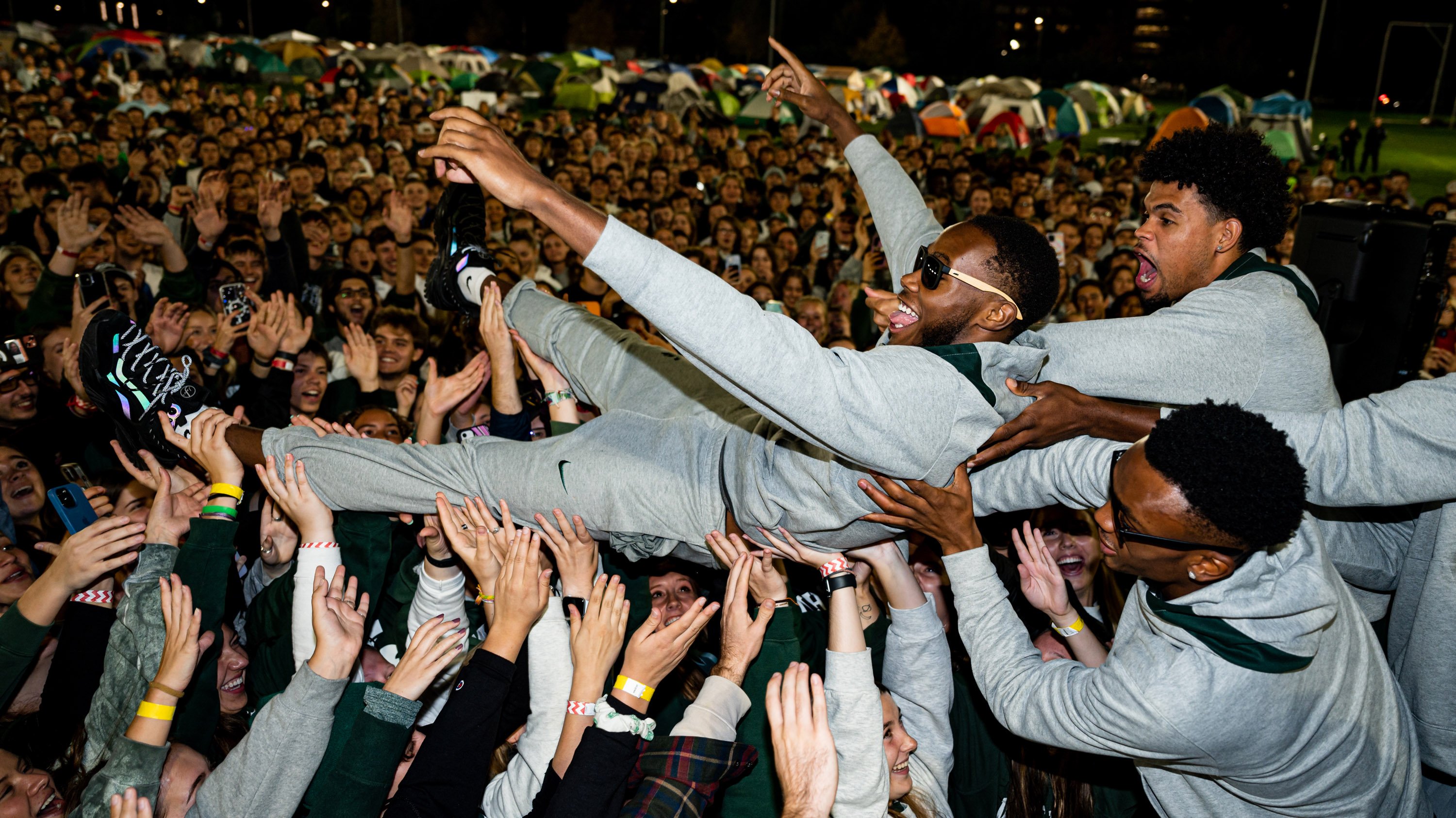 Tre Holloman being lifted up by teammates during Izzone campout