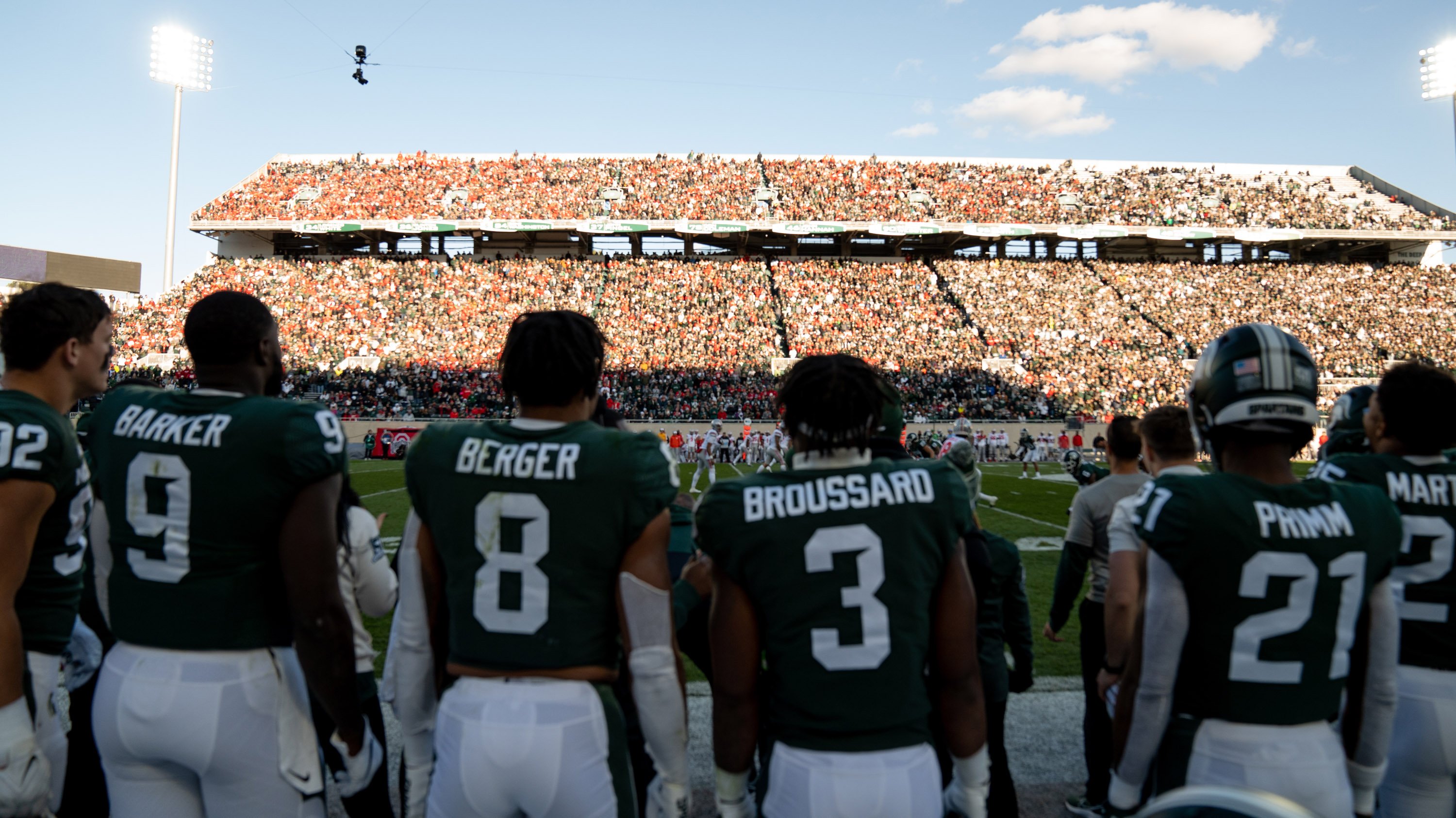 Members of MSU football team in front of crowd at Spartan Stadium