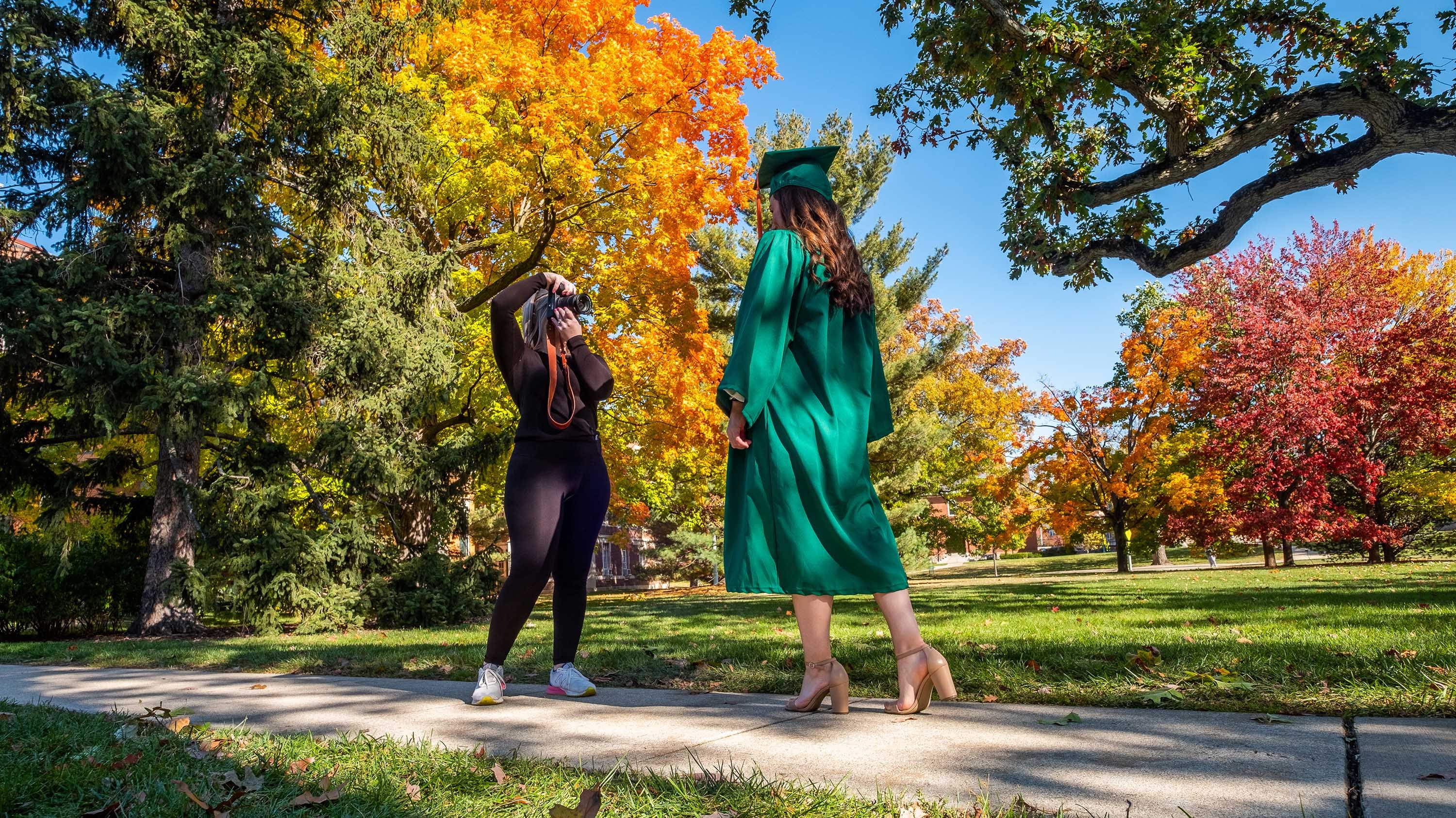 Katie McMillan, MSU senior is photographed in her cap and gown by sister, Bridget McMillan near Linton Hall.