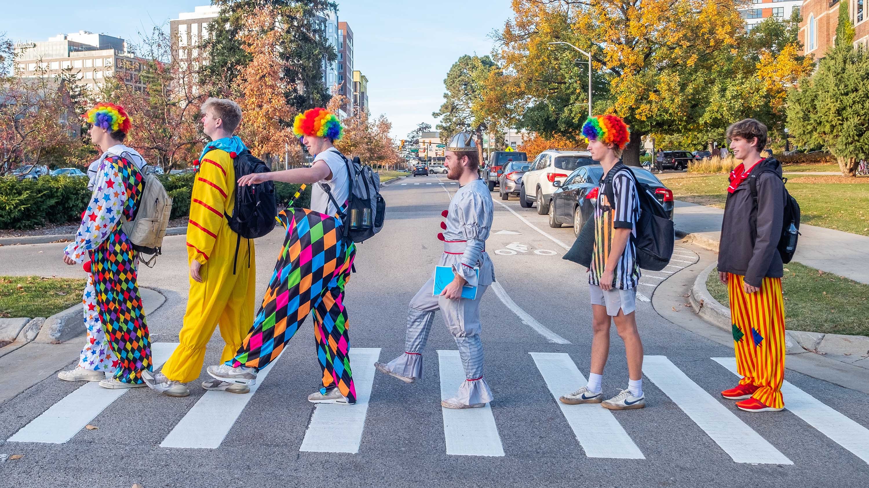 Students dressed as clowns walking on a crosswalk