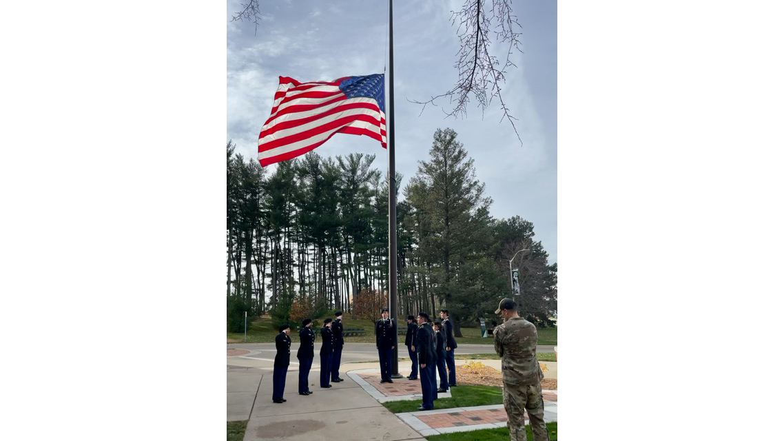 Members of AFROTC raising flag at Dem hall plaza dedication